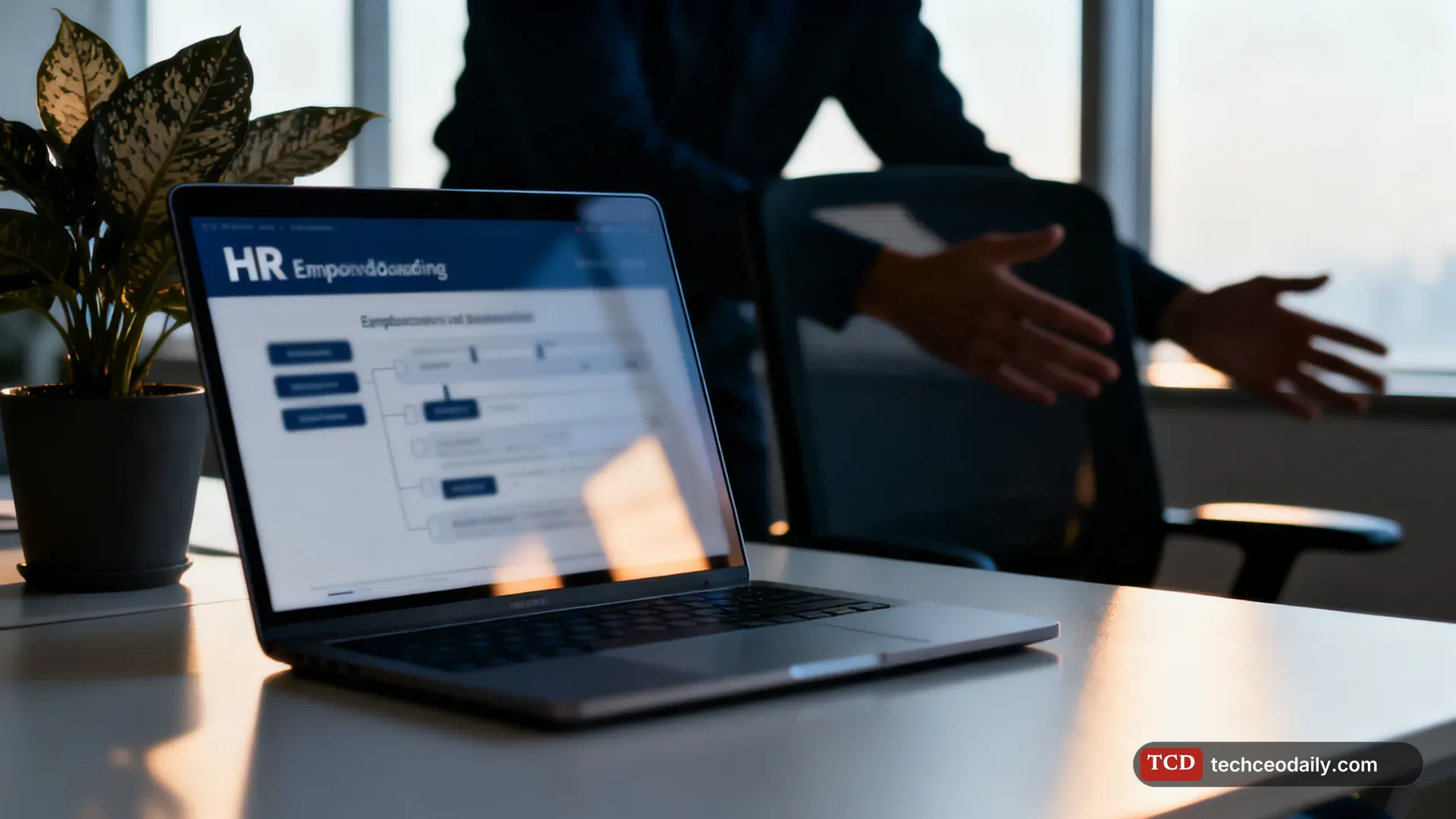 An HR office with a laptop showing a blurred employee onboarding workflow, illustrating Ema raises $77 million for “AI employees” that automate HR, IT and finance work