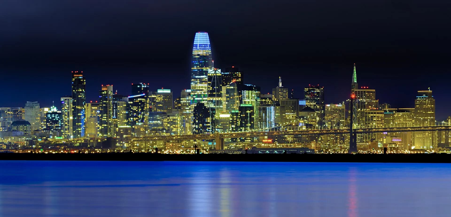 San Francisco skyline at night with Salesforce Tower, the Transamerica building and the Bay Bridge