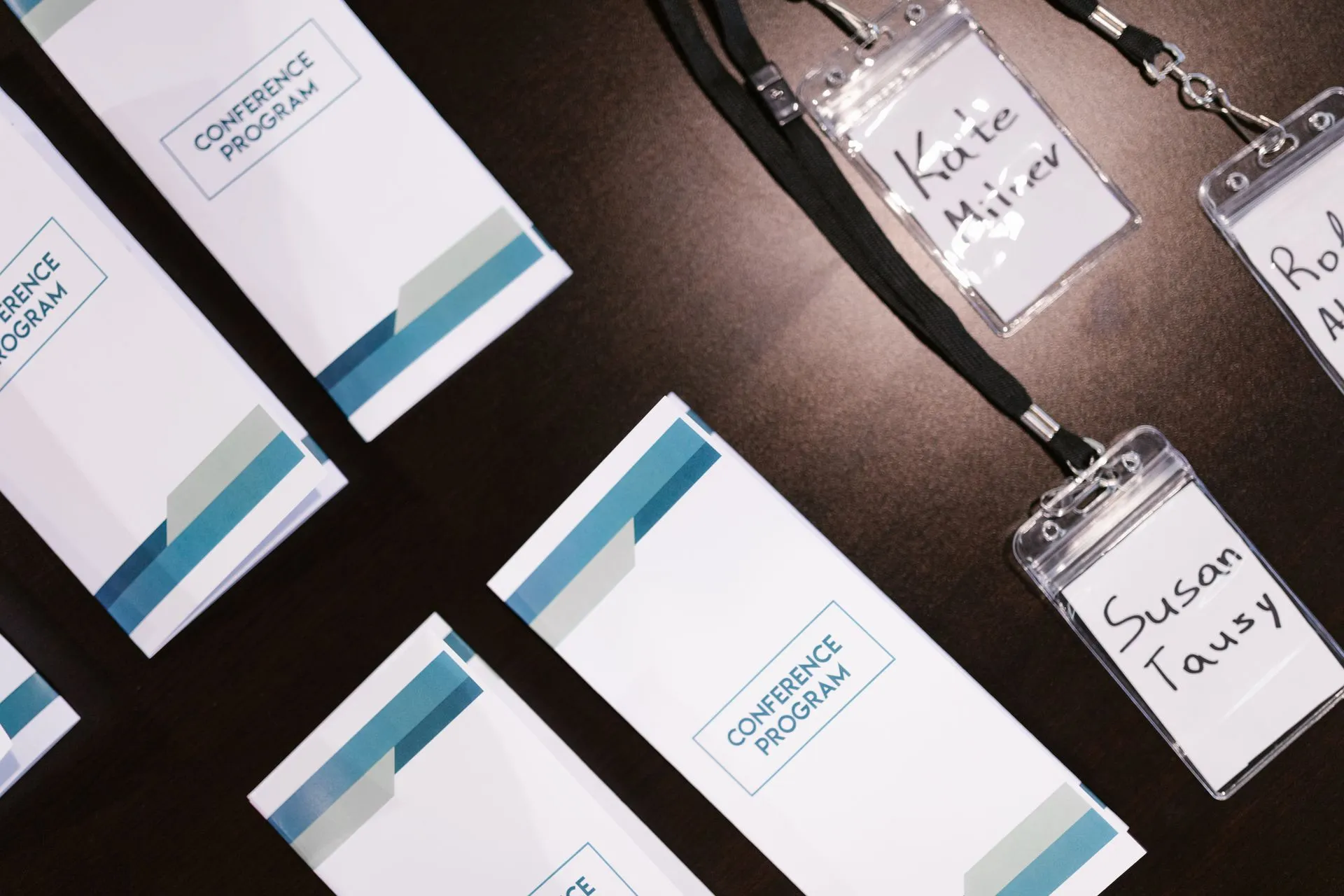 High-angle view of conference programs and name badges on a table, ideal for corporate event visuals, illustrating Salesforce requires AI agent identity as Cyera and Island raise $800
