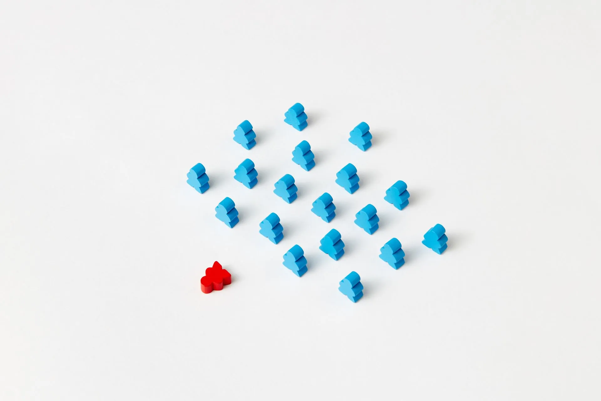 A distinctive red game piece stands out among blue meeples on a minimalist white background, symbolizing individuality, illustrating OpenAI's GPT-6 Astra swapped in a human-made StarCraft bot