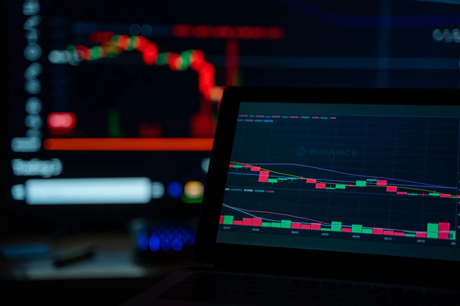 A dimly lit desk setup displaying cryptocurrency trading charts on multiple screens, illustrating Cribl and CData launch AI gateways to cap spending as one test finds a 178x cost gap