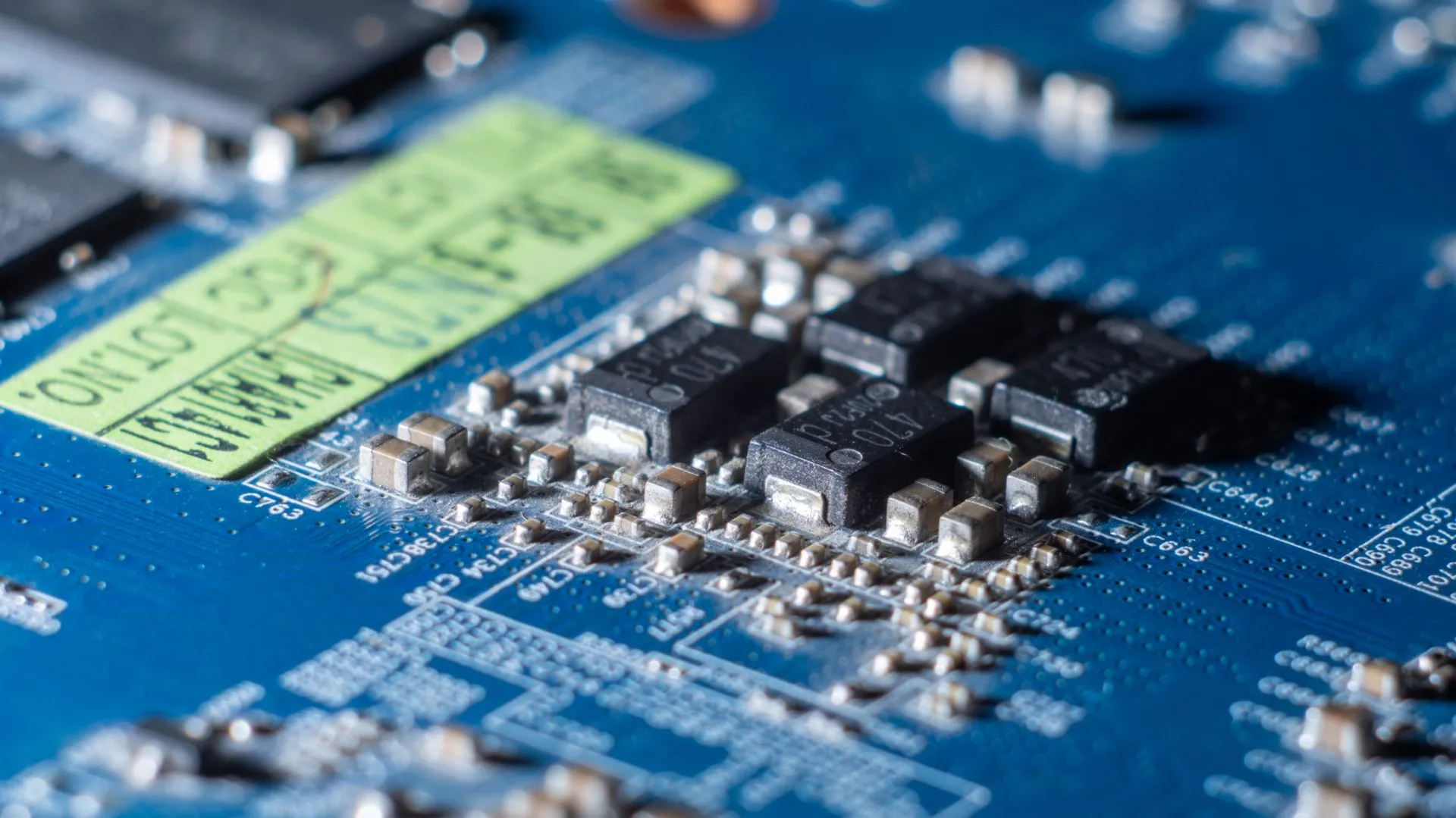 Detailed macro shot of a blue circuit board with multiple microchips and electronic components, illustrating AI infrastructure ROI