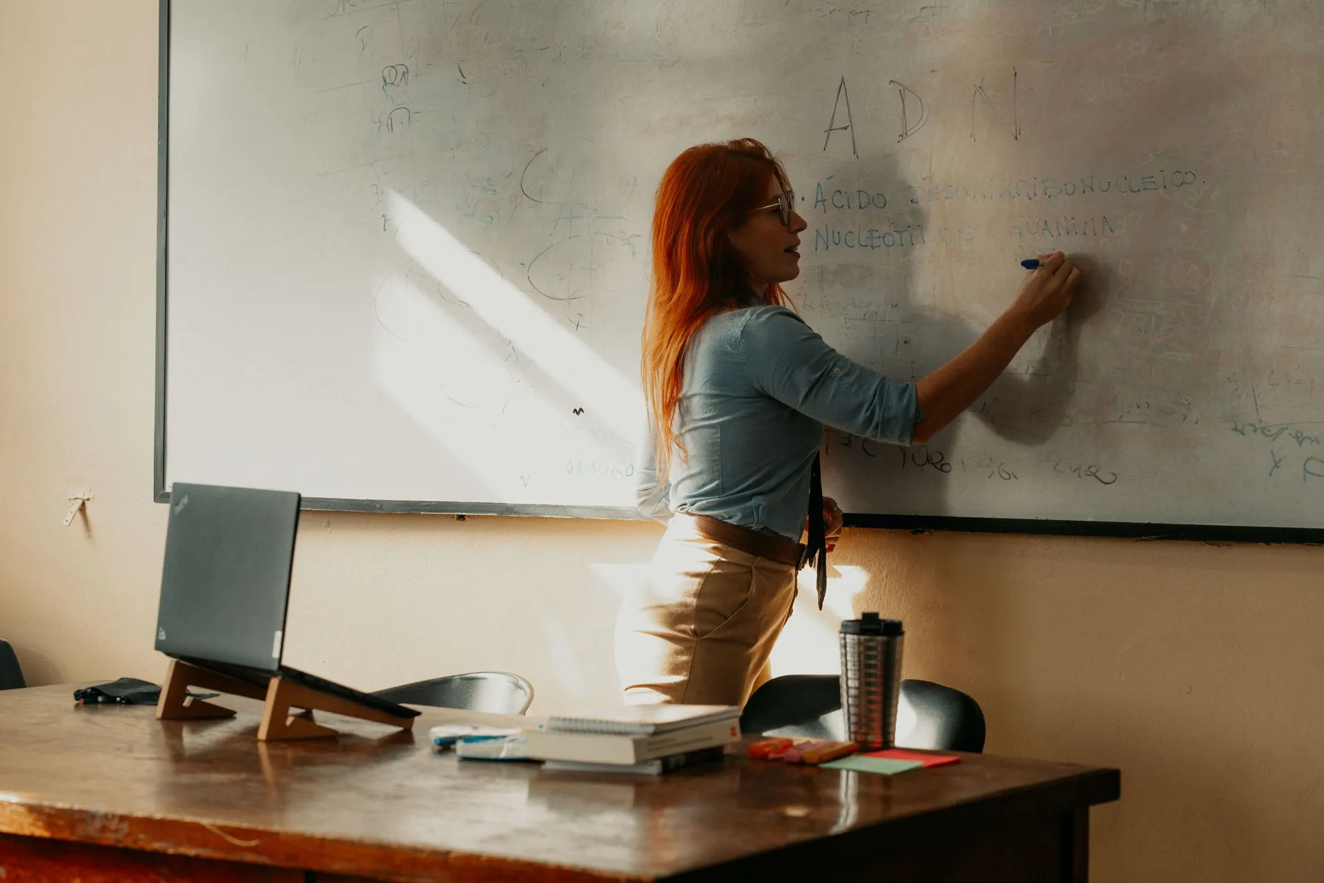 A teacher instructs at a whiteboard inside a Buenos Aires classroom, focusing on lesson planning, illustrating AI skills gap