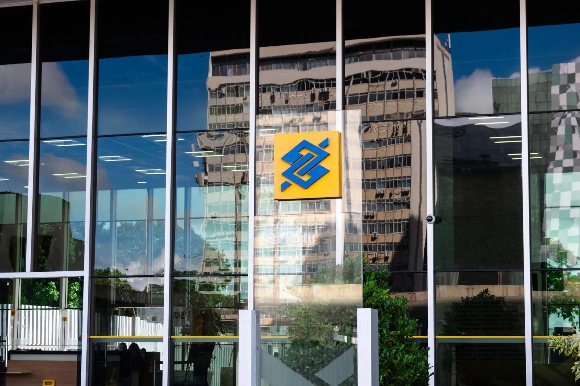 Modern building exterior in Brasília, Brazil, featuring reflective glass and iconic Banco logo, illustrating Microsoft, Meta steer staff from Claude as Barclays expands it