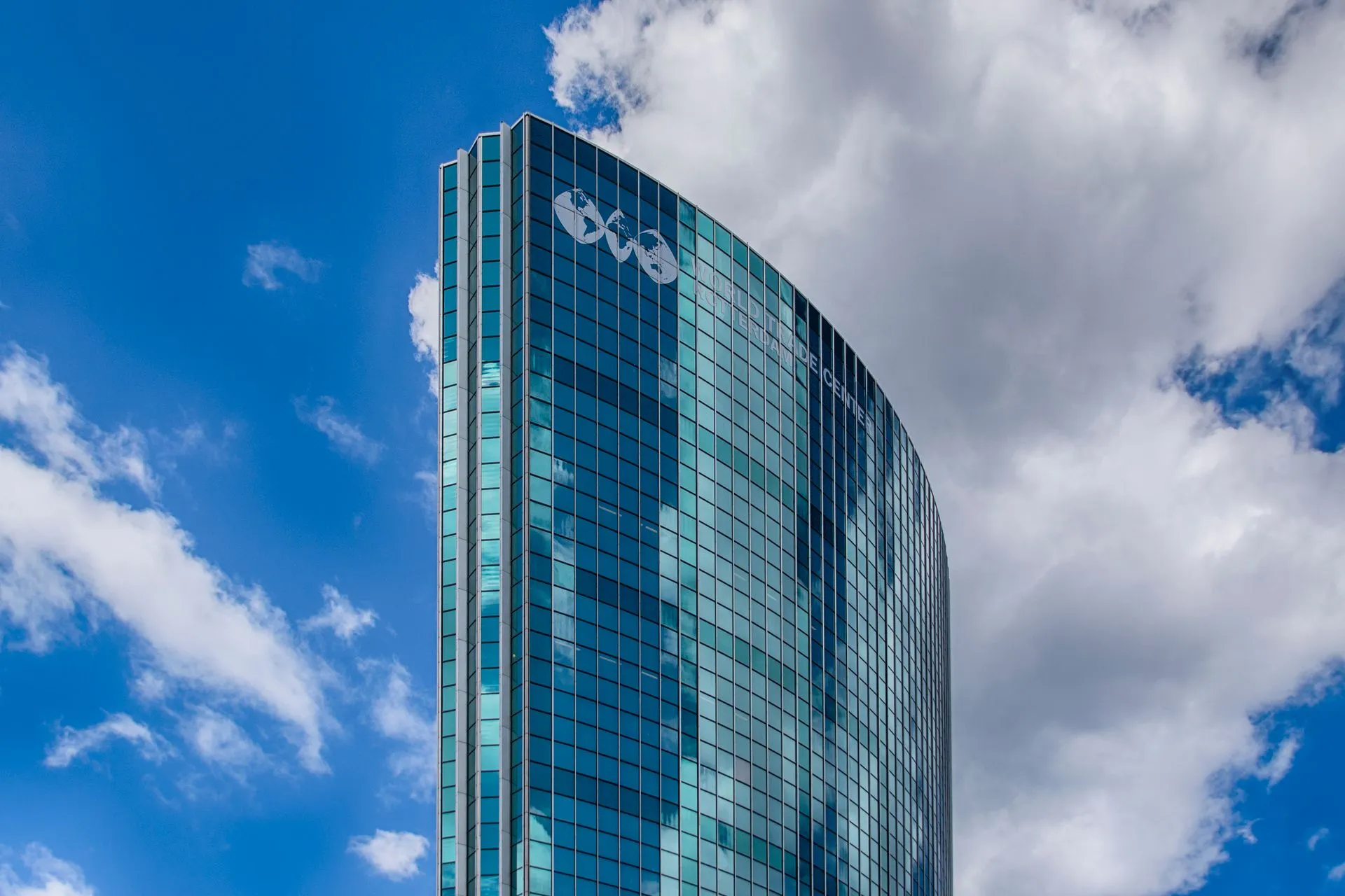 A striking modern skyscraper with glass facade reflecting clouds in Rotterdam, Netherlands, illustrating Amazon seeks to sell $8 billion of Nvidia chips to investors and lease them
