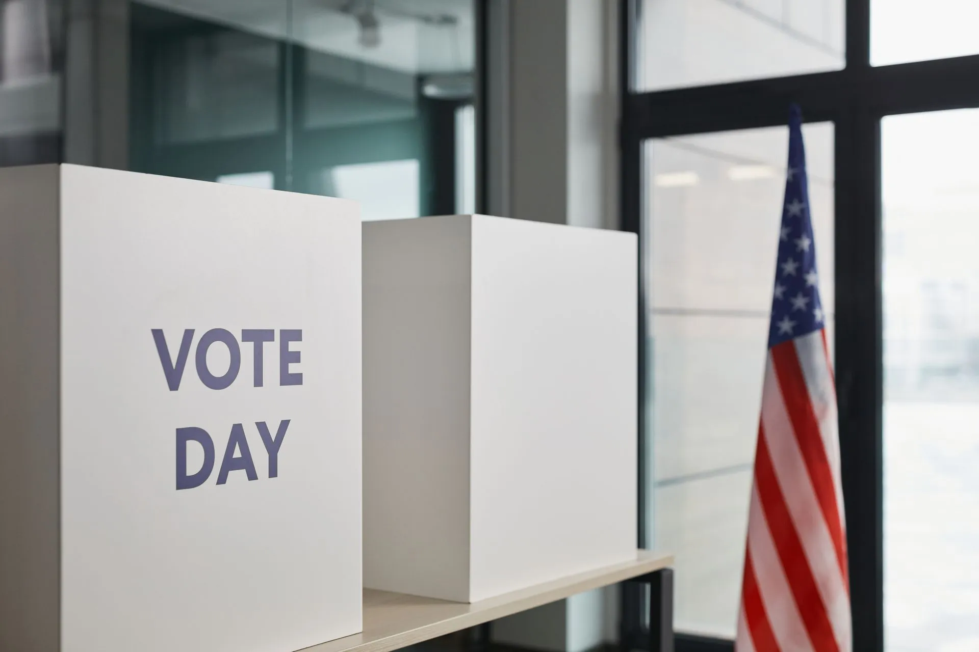 Voting booth setup with American flag, symbolizing election day, illustrating Anthropic usage policy update targets election deception and model abuse from November 12