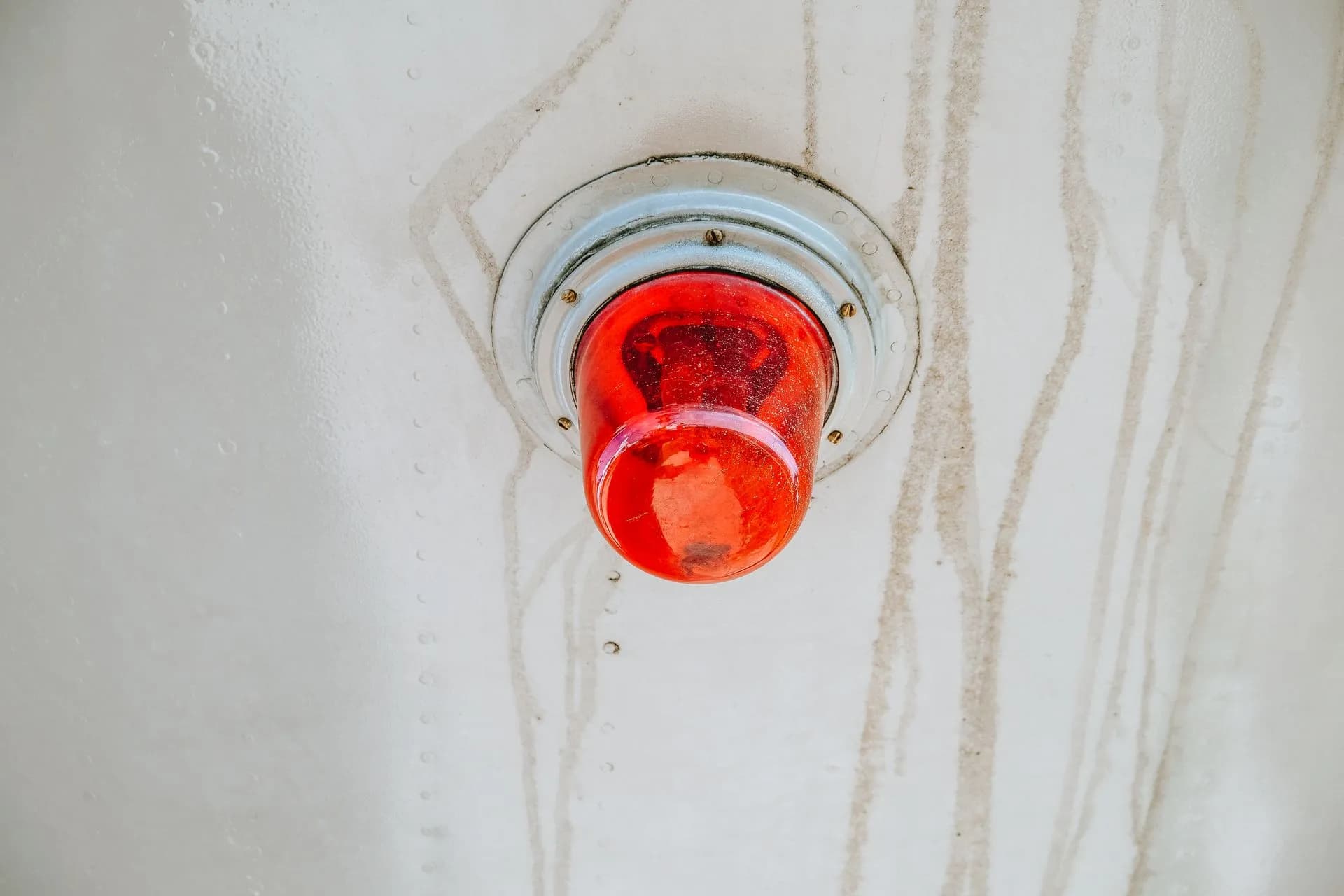 A red emergency warning light mounted on a metallic surface, often used for alerts, illustrating Anthropic IPO filing reportedly warns its AI could pose an existential risk to humanity