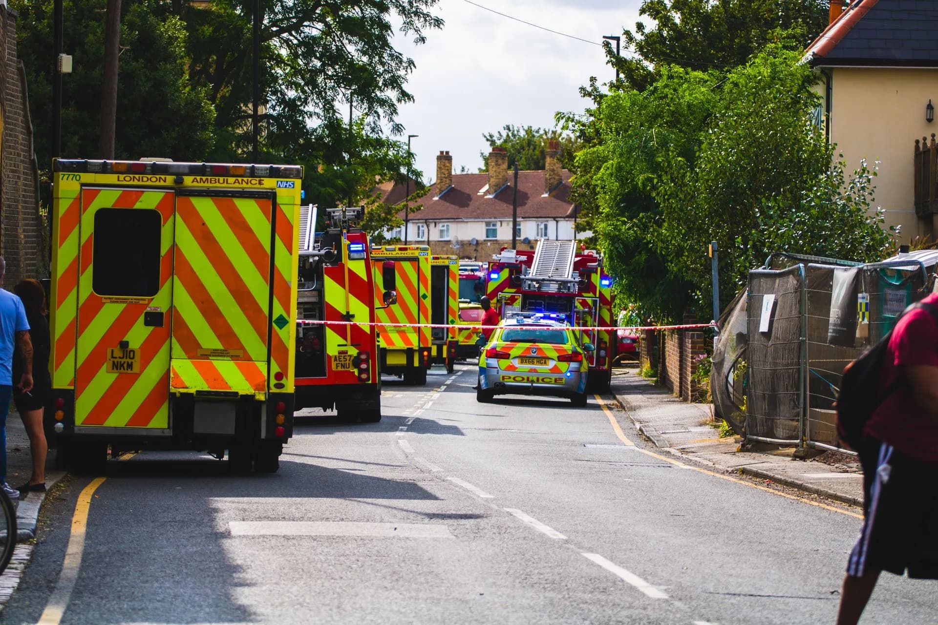 Emergency vehicles respond to an incident on a residential street, road closed, illustrating Atos wins Met Police application management contract worth up to £350 million
