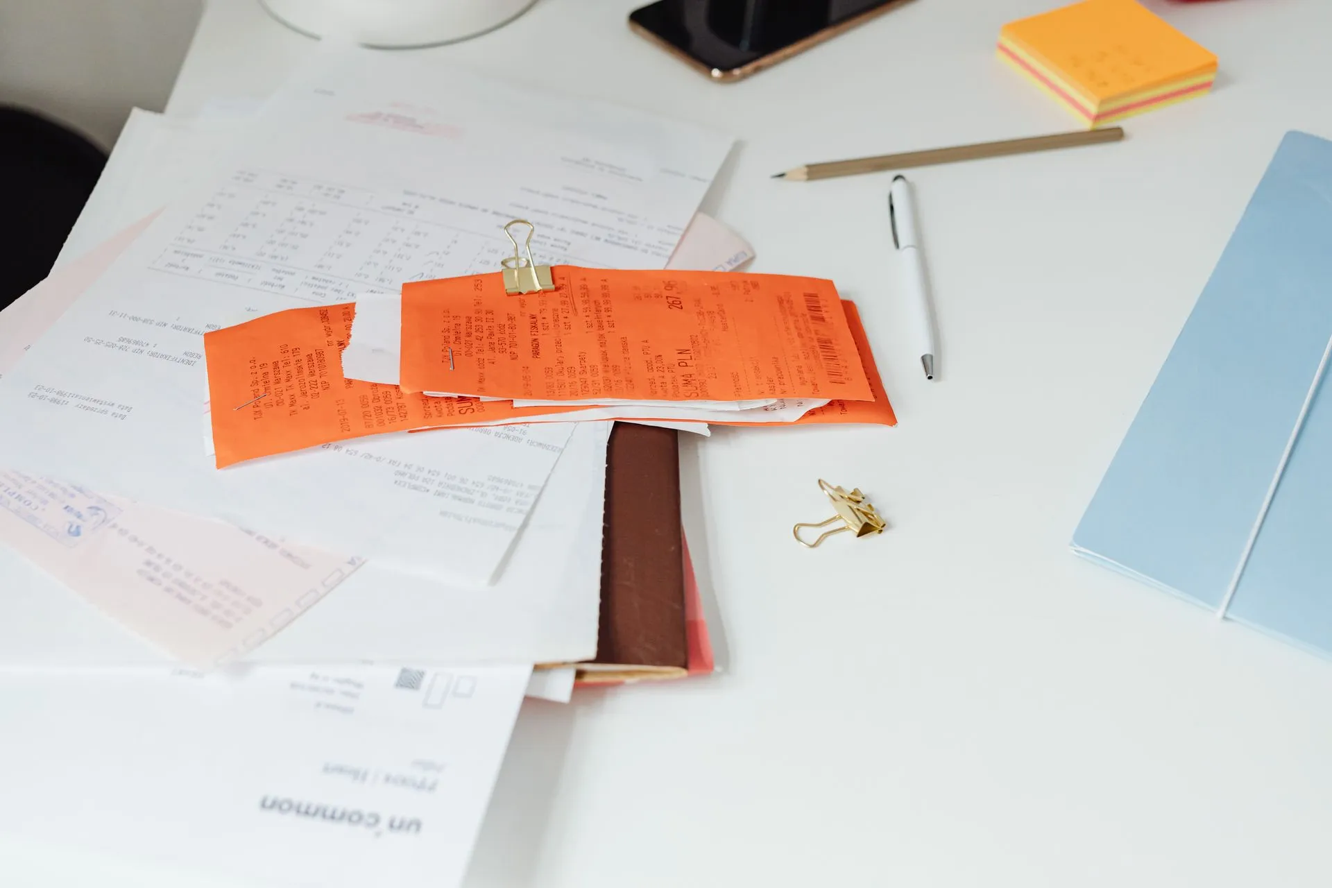 Close-up of a tidy desk with receipts, documents, and office stationery for business organization, illustrating Basware completes Trustpair acquisition to tie invoice checks to payment