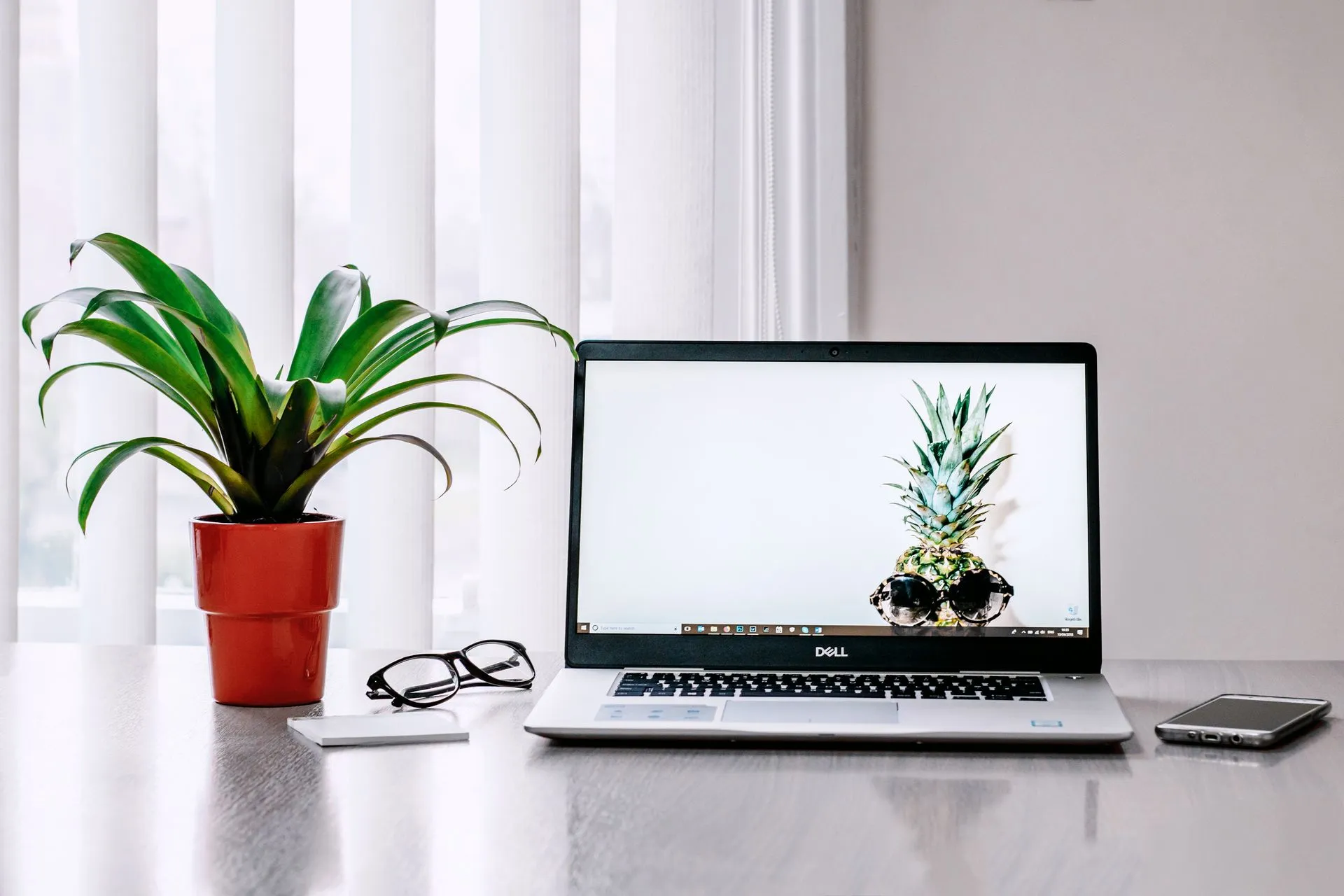 A stylish workspace featuring a laptop, plant, and smartphone on a desk, illustrating Blackfuel exits stealth with over $250 million in contracted revenue to sell AI by the token