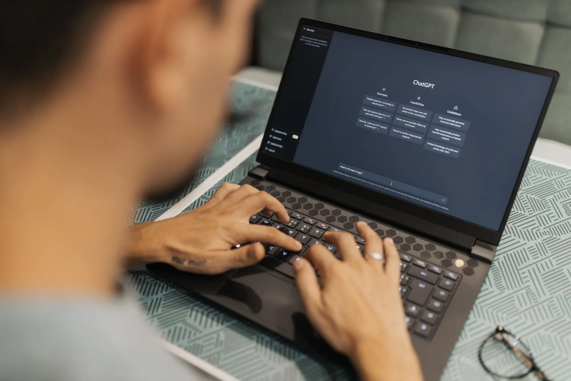 A focused individual types on a laptop running AI software indoors, illustrating Capital One agentic AI strategy puts data first as Plaid brings bank links to Decagon