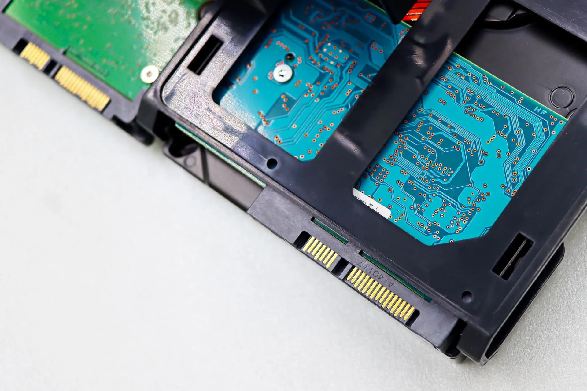 Detailed view of computer hard disk drive components, showcasing circuitry and connectors, illustrating Chainlink and Oracle move to connect banks to Swift blockchain ledger for 24/7