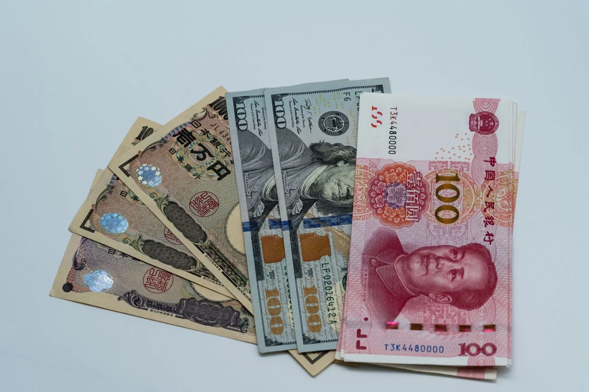 Various international currency notes including US dollars, yen, and yuan arranged on a surface, illustrating Citi instant payments go live on Swift's scheme in multiple markets, a