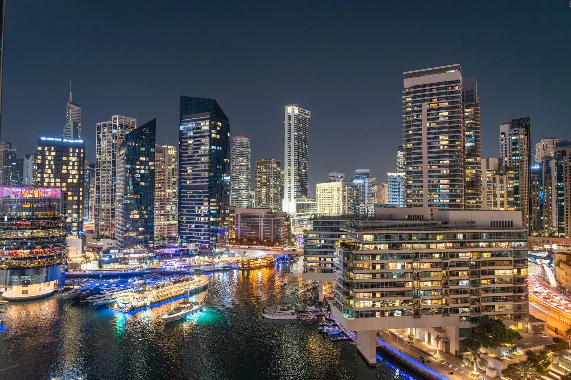 Stunning night view of Dubai Marina with illuminated skyscrapers and reflections on the water, illustrating Citi Token Services hits Japan and UAE
