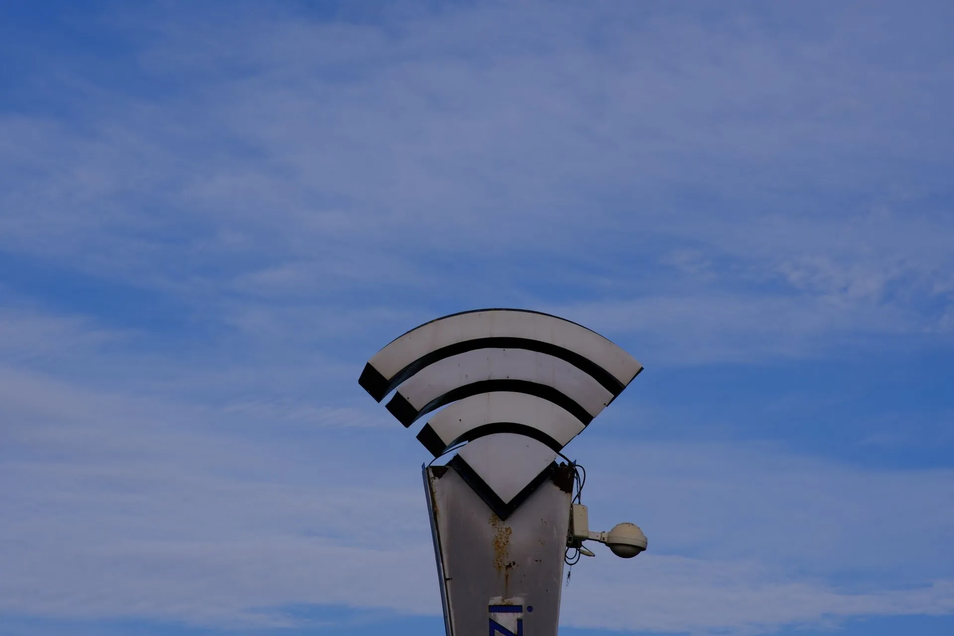 A WiFi symbol sculpture set against a clear blue sky in İzmir, Türkiye, illustrating ClingSTUN Linux backdoor hides in STUN traffic, exploiting 30+ IoT and router flaws, Fortinet says