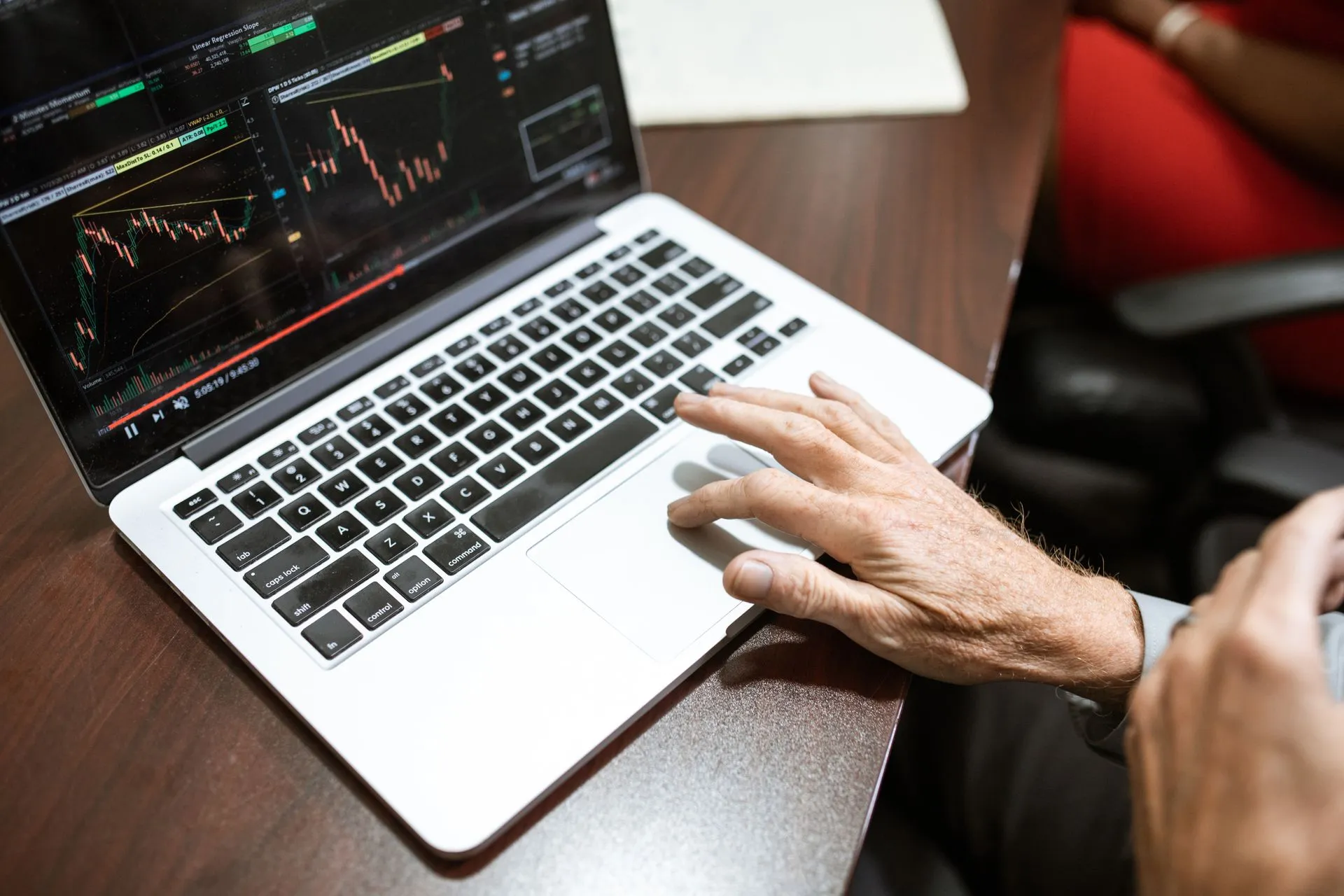 Close-up of hand using laptop for stock market analysis in office setting, illustrating Cloudflare Basin goes GA with zero egress fees as K2 event streams enter beta