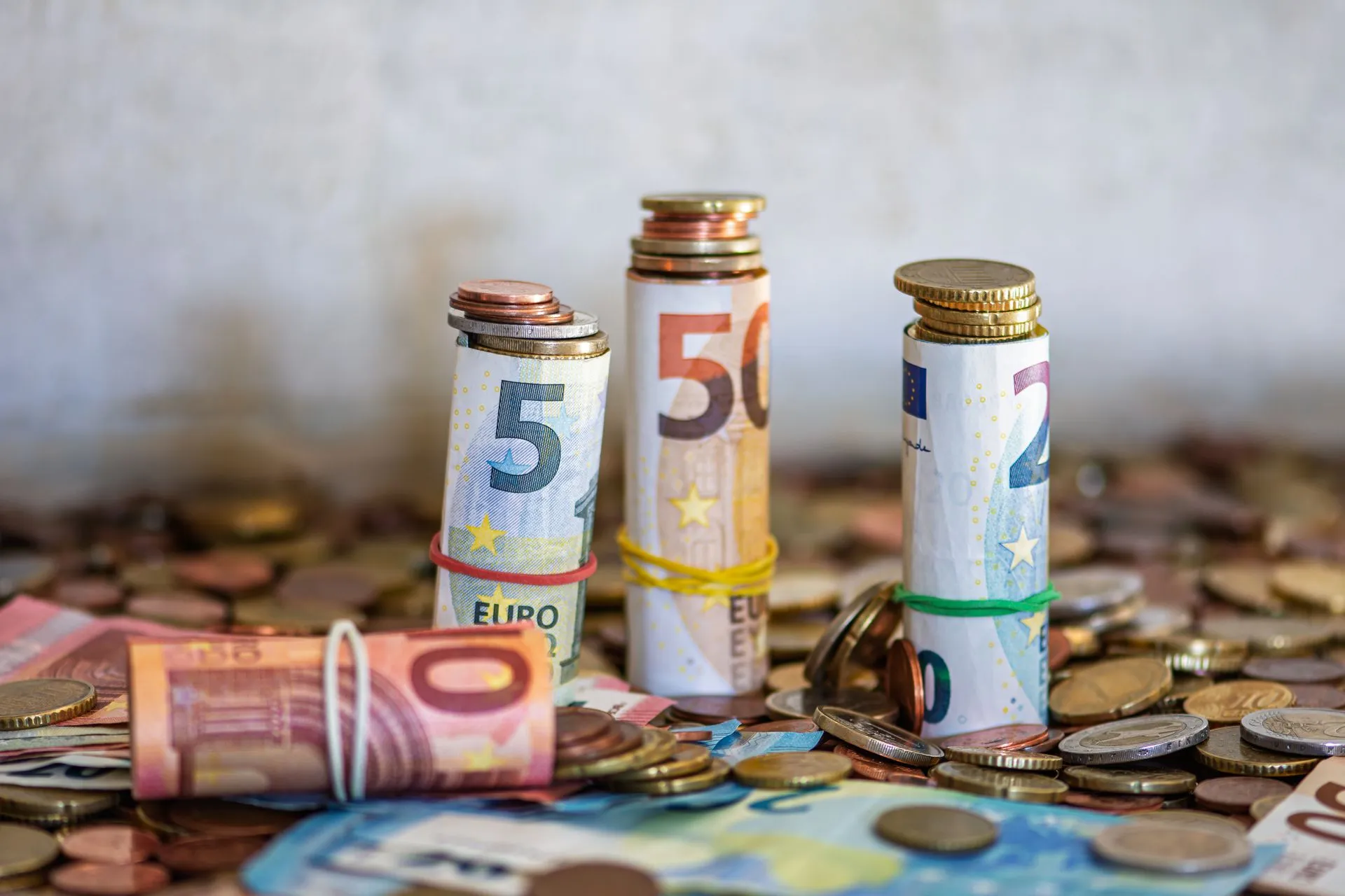 Close-up of rolled Euro banknotes and coins on a table, symbolizing finance and savings, illustrating Senate passes Common Cents Act, sending penny phase-out and nickel rounding to