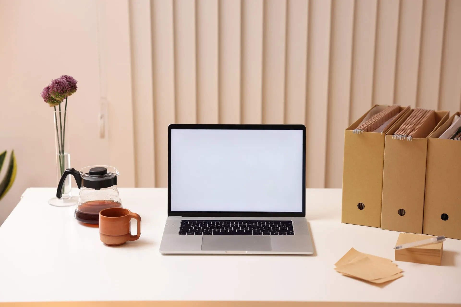 A minimalist workspace featuring a laptop, folder organizers, and coffee, ideal for productivity, illustrating Microsoft Copilot gets file access as Google tests Gemini control of the