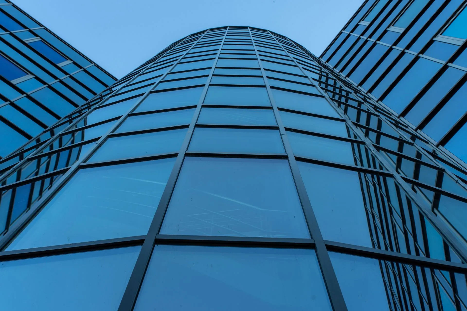 Dynamic view of a contemporary skyscraper facade with reflective glass panels, illustrating CoreWeave Vera Rubin NVL72 enters production with Cognition, reporting up to 4.8x gains