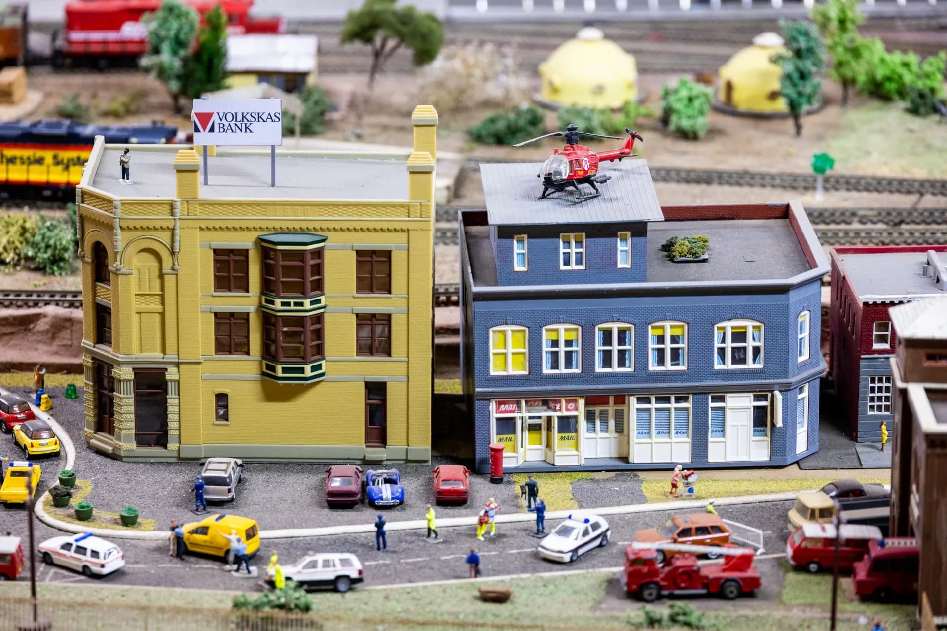Intricate miniature city scene with model buildings, vehicles, and figures creating a lively urban setting, illustrating Credit union bank deal No. 2 in a month for Gulf Winds as