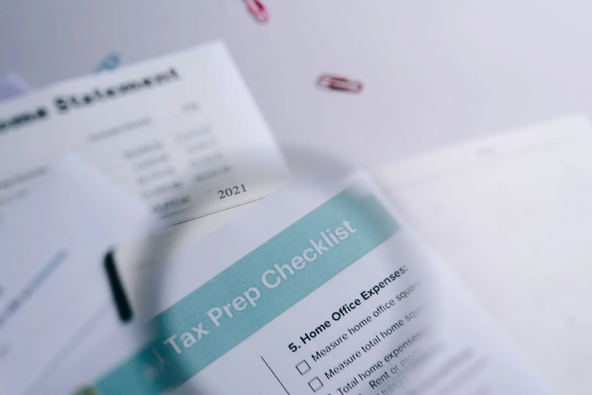 Close-up of tax preparation checklist and income statement with paperclips, illustrating State bank regulators release AI supervisory framework with three-tier risk ratings