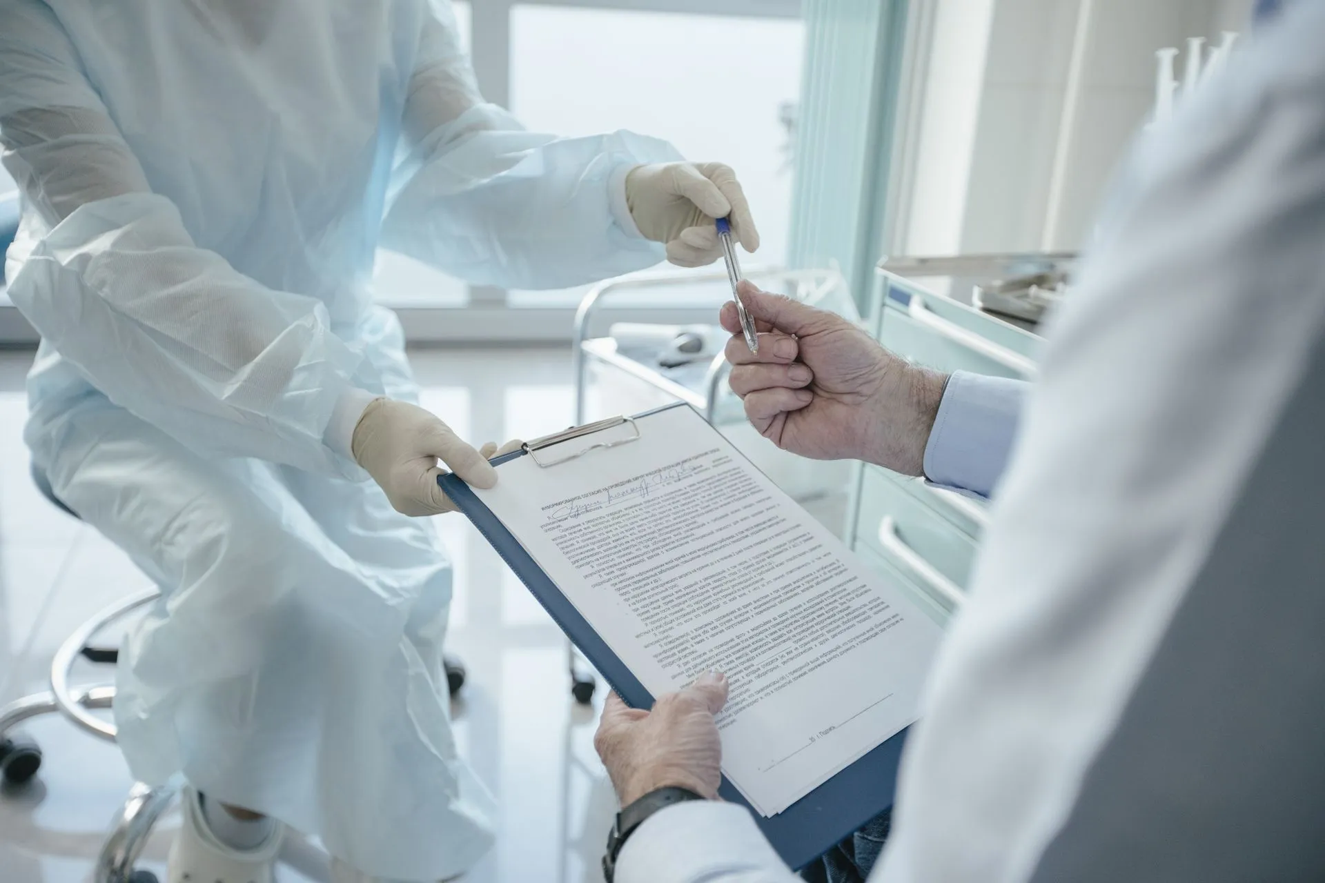 A doctor hands a clipboard to a patient for signature, highlighting medical professionalism, illustrating DC Medicaid data exposure hit 399,086 beneficiaries via hidden details in web
