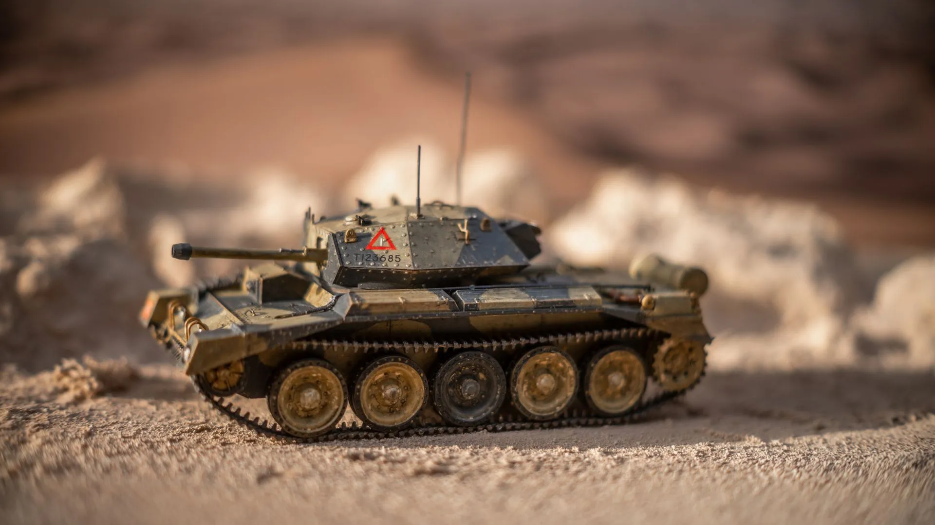 A detailed model tank set on a sandy landscape with a warm and soft light, creating a realistic military diorama effect, illustrating Overland AI's Ibex and Furientis' $25M show defense