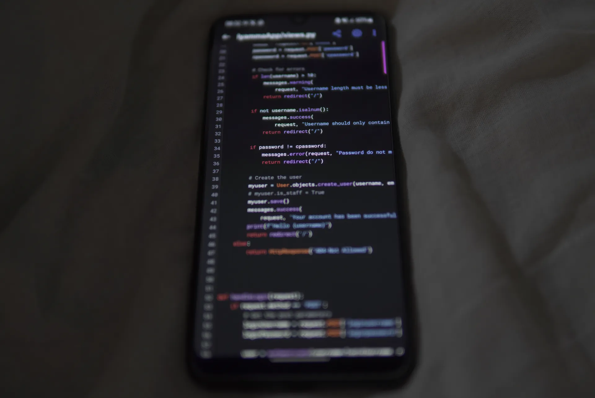 Close-up of a smartphone showing Python code on the display, showcasing coding and technology, illustrating Device code phishing kits beat MFA at thousands of firms, from EvilTokens to