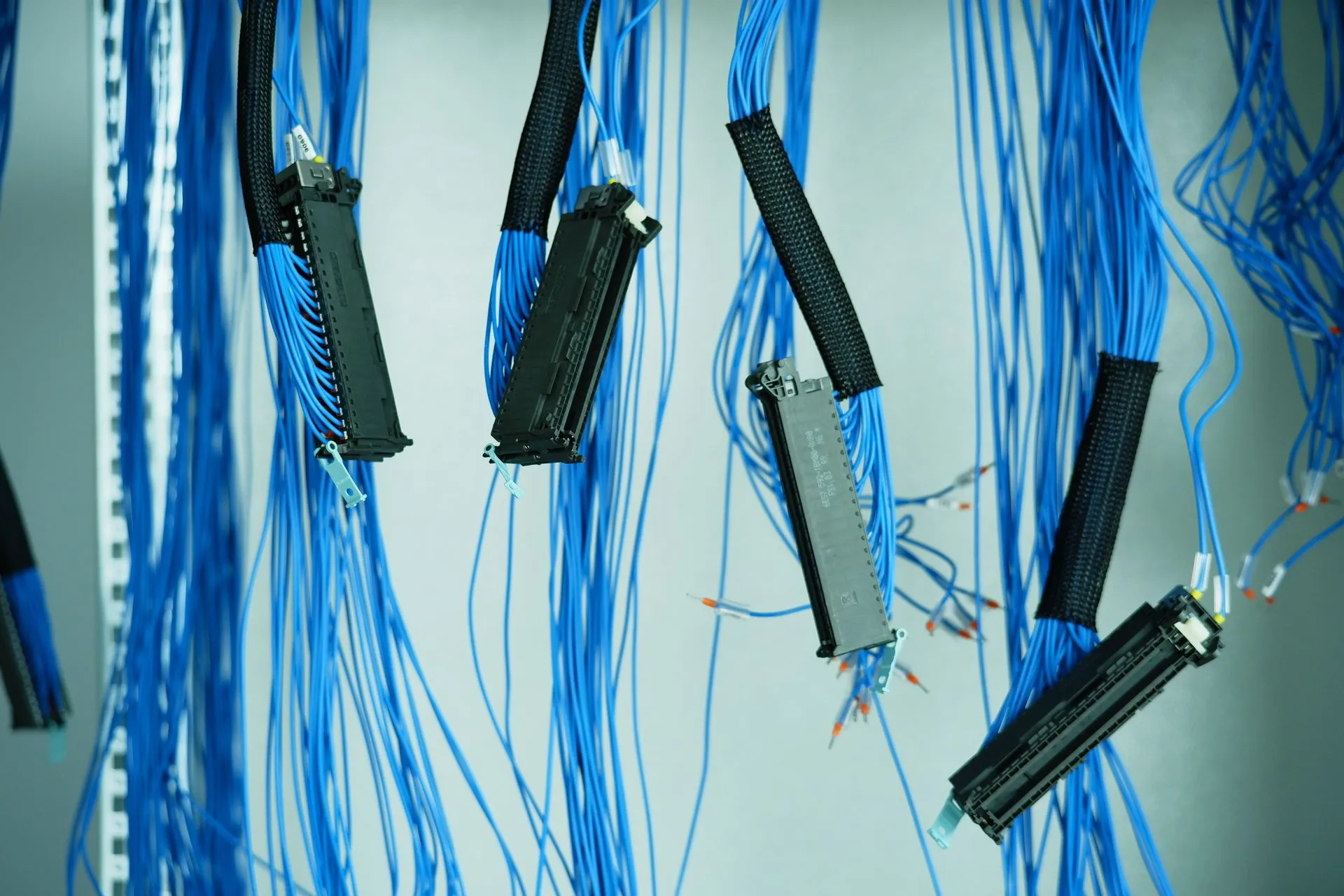Close-up of blue ethernet cables hanging in a data center, highlighting technology connections, illustrating DIVD breach