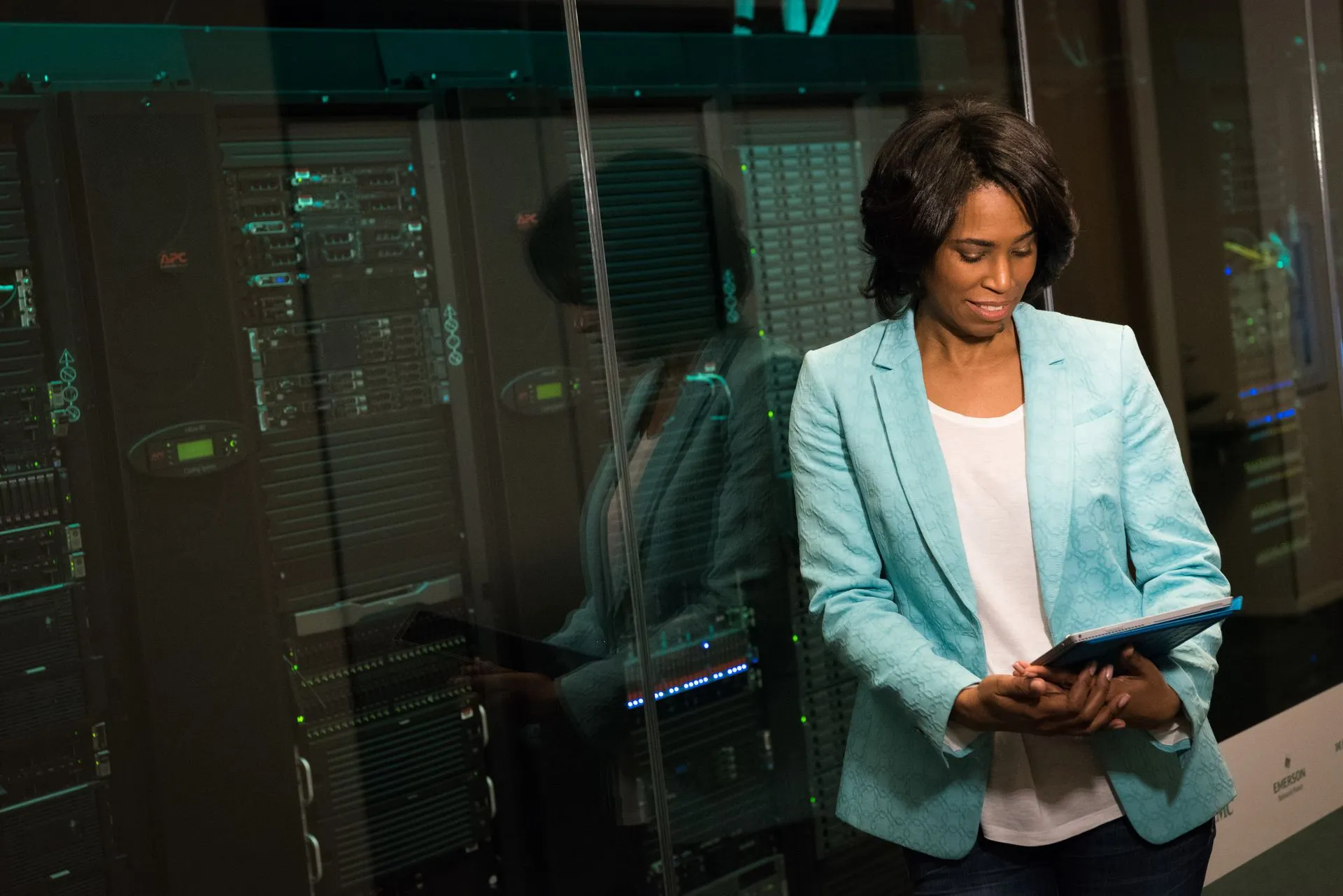 Female IT professional examining data servers in a modern data center setting, illustrating Salesforce's Koa and Harvey's Tenet show vendors building domain-specific AI models