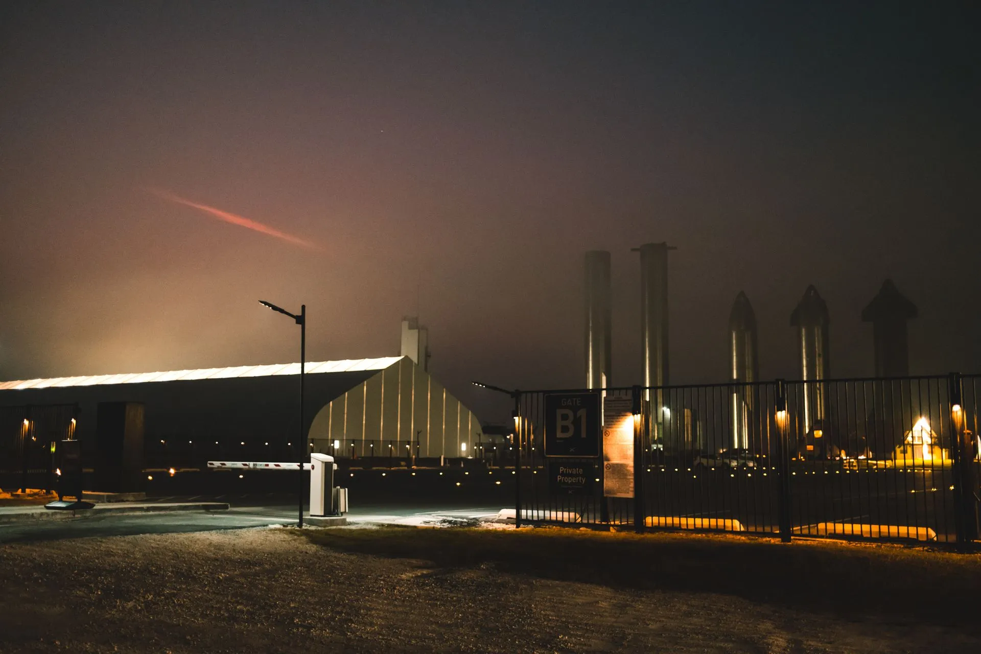 Dramatic night view of SpaceX facility with fog and lights in Brownsville, Texas, illustrating Elon Musk's net worth tops $1 trillion again as SpaceX stock jumps nearly 8%