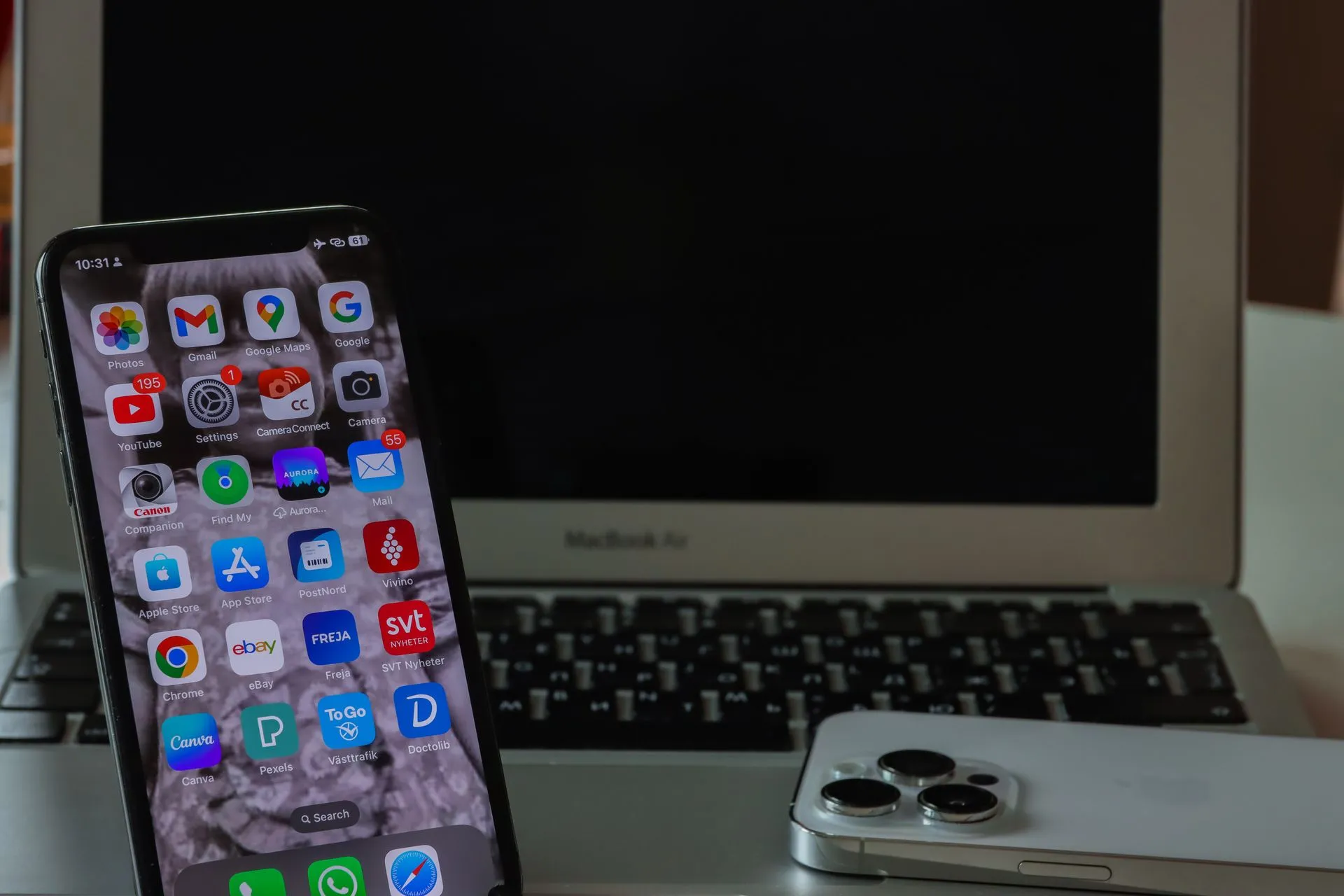 Close-up of a smartphone and laptop on a desk, displaying productivity and connectivity, illustrating Exchange Server vulnerability could let a signed-in attacker read other users'