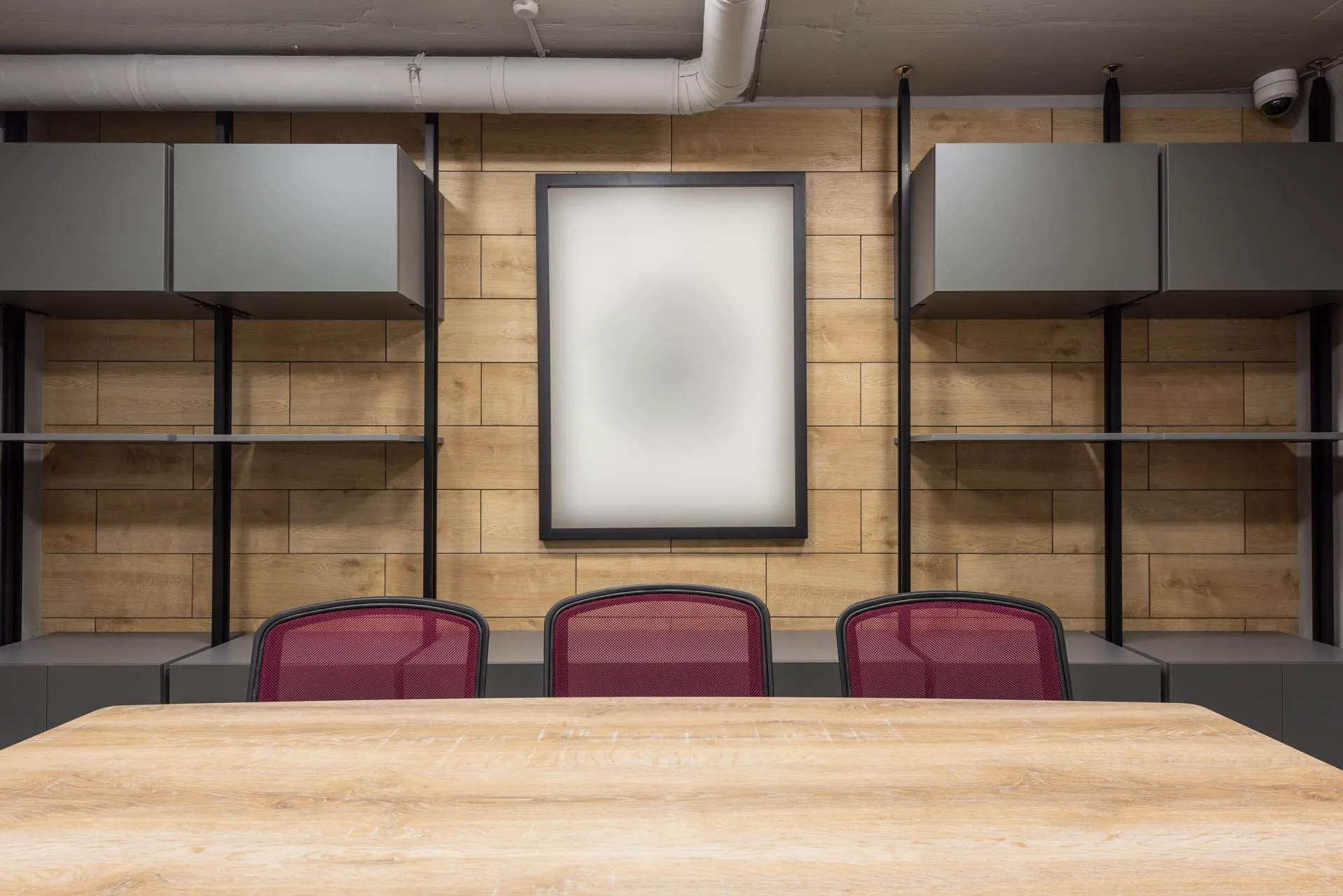 Contemporary interior of new boardroom equipped with wooden table and red office chairs, illustrating Factory CEO accuses ex-board adviser of confiding in Cognition