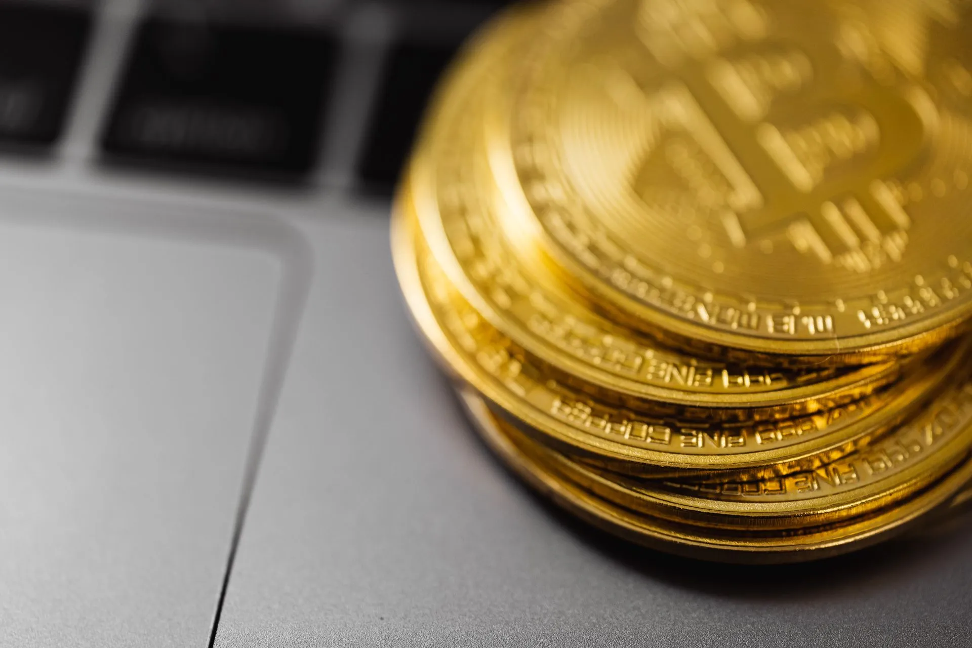 Stack of gold Bitcoin coins on a laptop keyboard, symbolizing digital currency technology and wealth, illustrating FCA crypto authorisation gateway opens, with a February 28 deadline