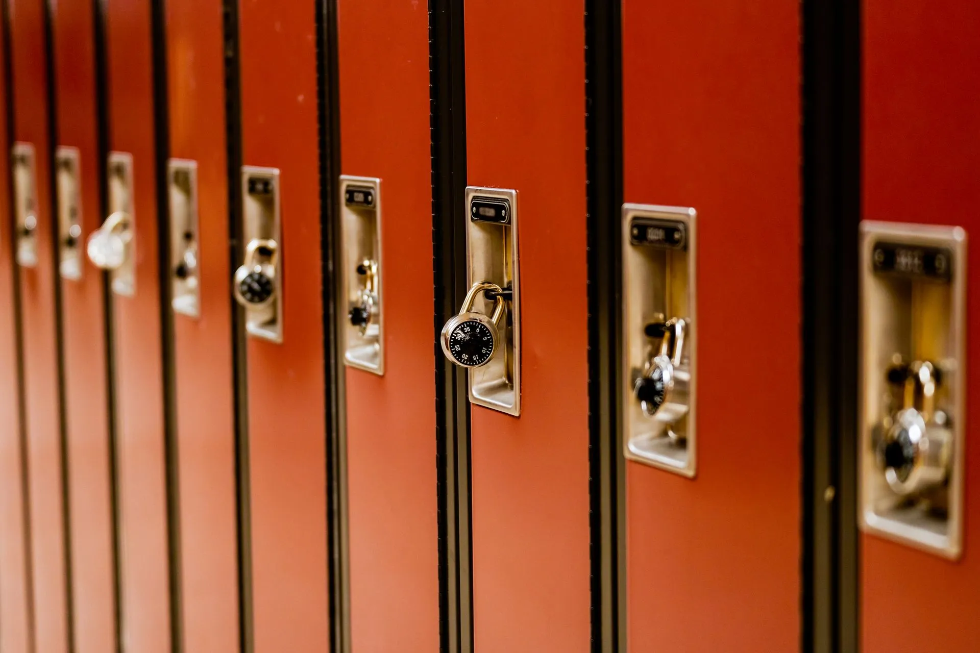 A line of brown school lockers with padlocks arranged indoors, providing secure storage, illustrating FDIC orders Old Glory Bank to fix capital shortfall after leverage ratio falls to
