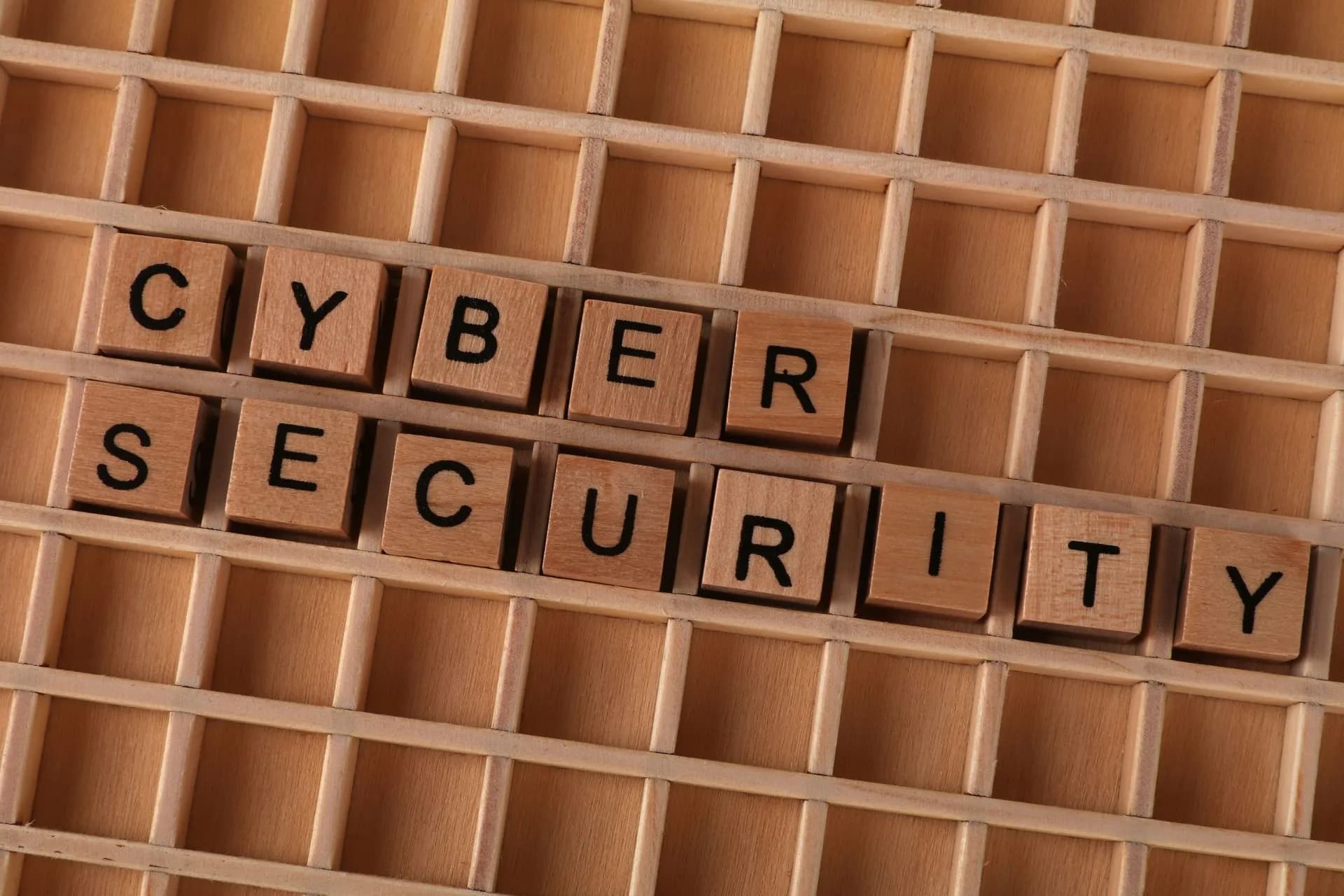 Wooden letter blocks spelling 'CYBER SECURITY' on a wooden grid background for data protection themes, illustrating FBI says FortiBleed attacks on Fortinet firewalls continue, locking