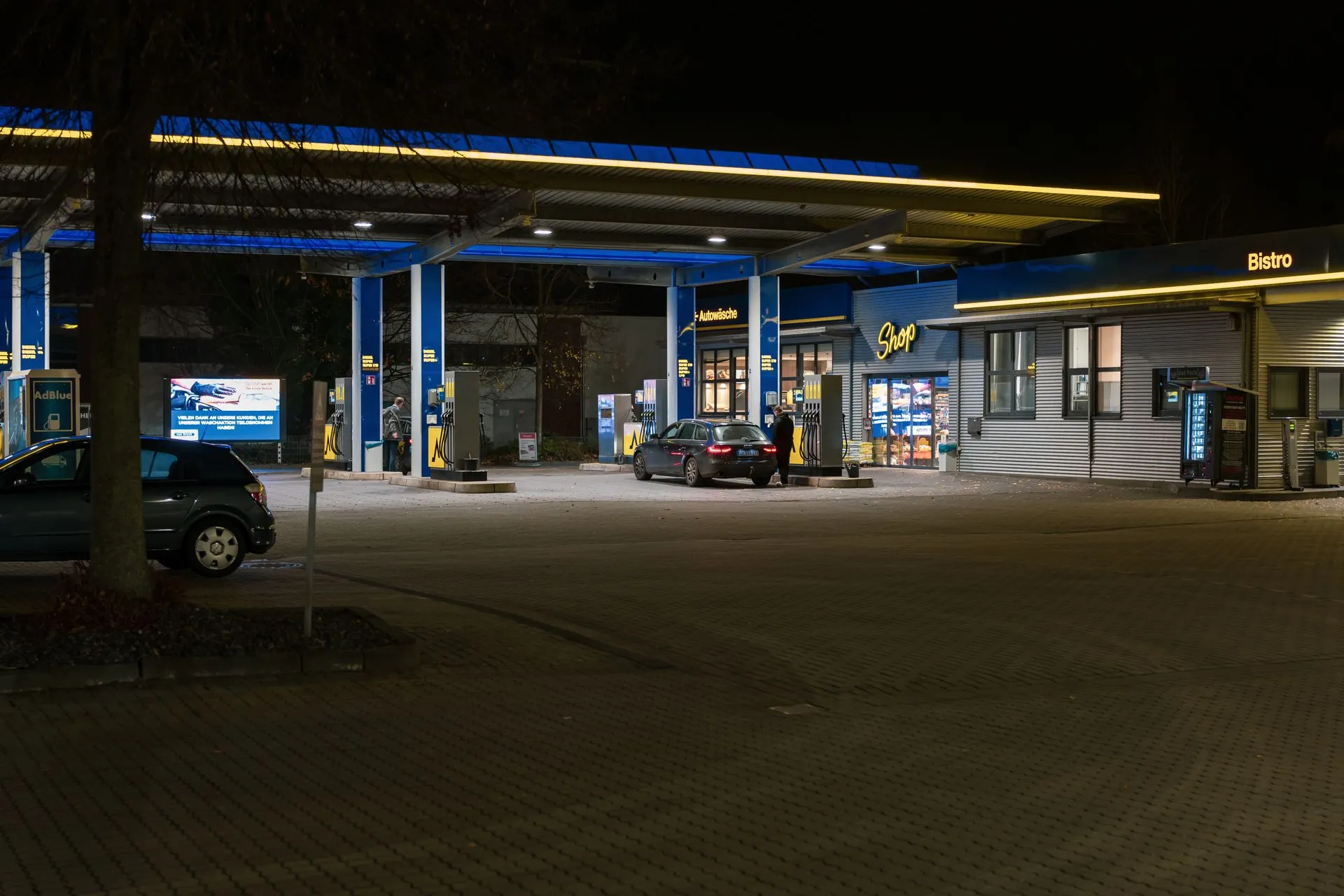 A well-lit gas station at night featuring cars and a bistro, creating a lively urban scene, illustrating FTC payments enforcement hits Nuvei, Humboldt and FleetCor
