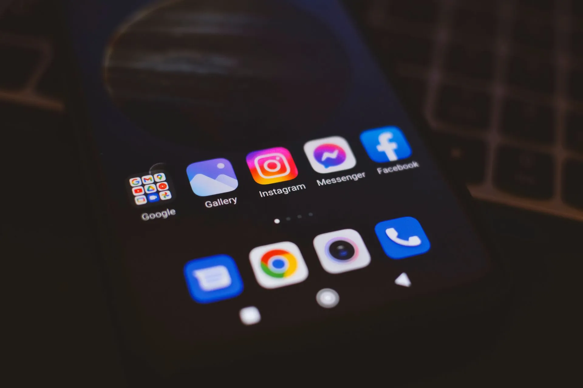 A smartphone displaying popular social media apps in a dimly lit environment, perfect for tech and communication themes, illustrating GitHub's open-source AI security agent helped find 24