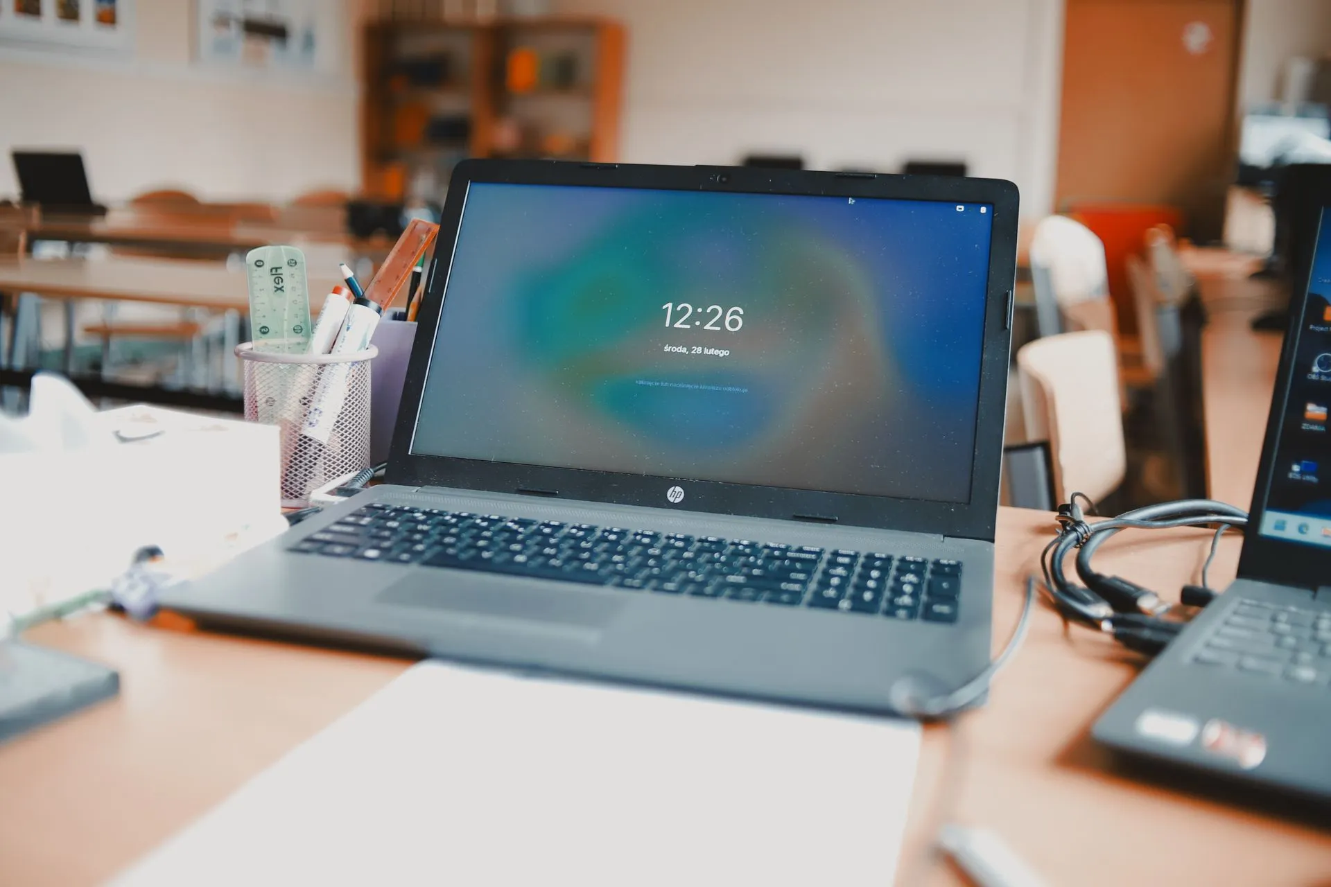 A classroom setting featuring laptops and desks, capturing a modern educational environment.