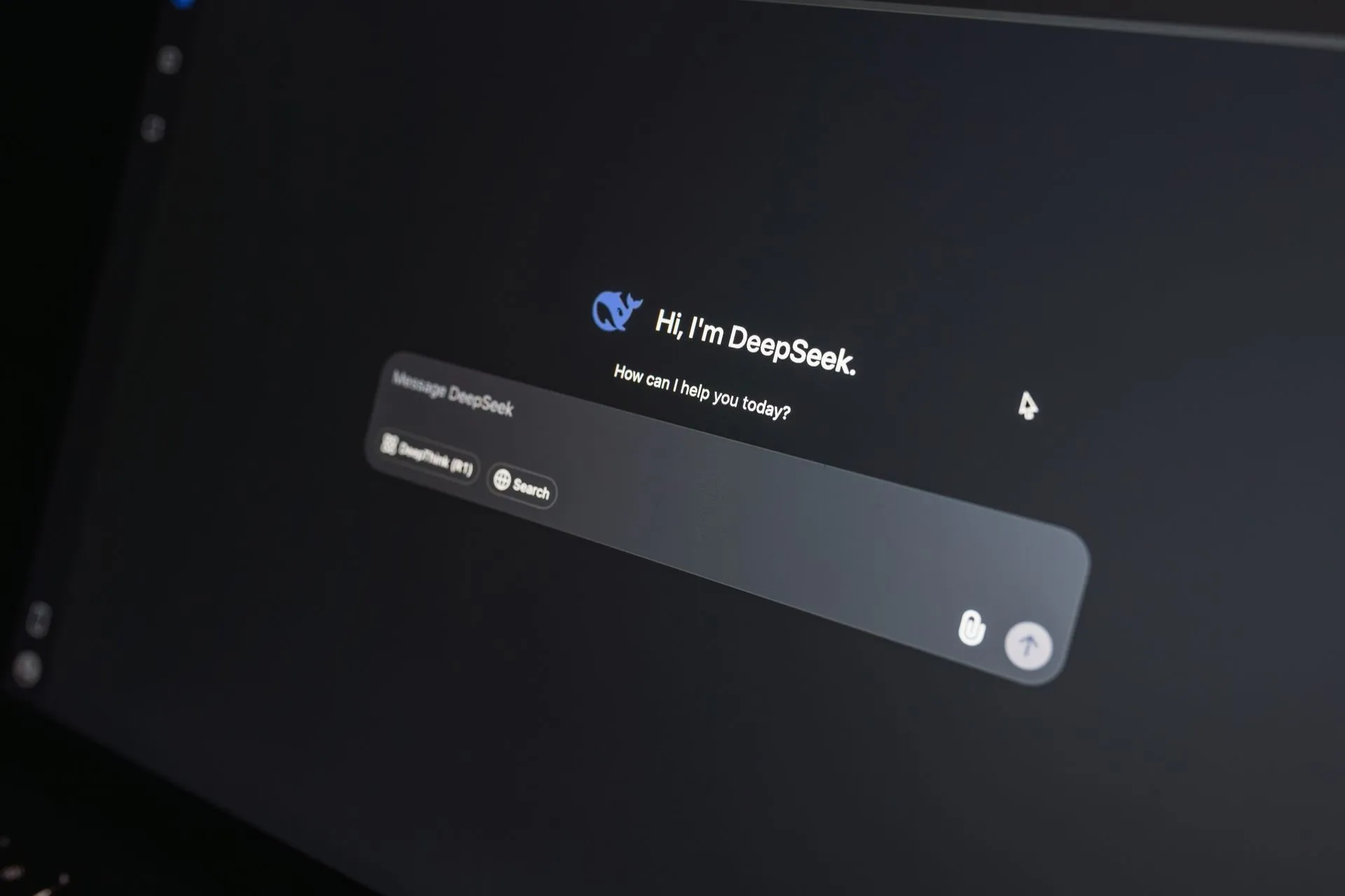 Close-up of DeepSeek AI chat interface on a laptop screen in low light.