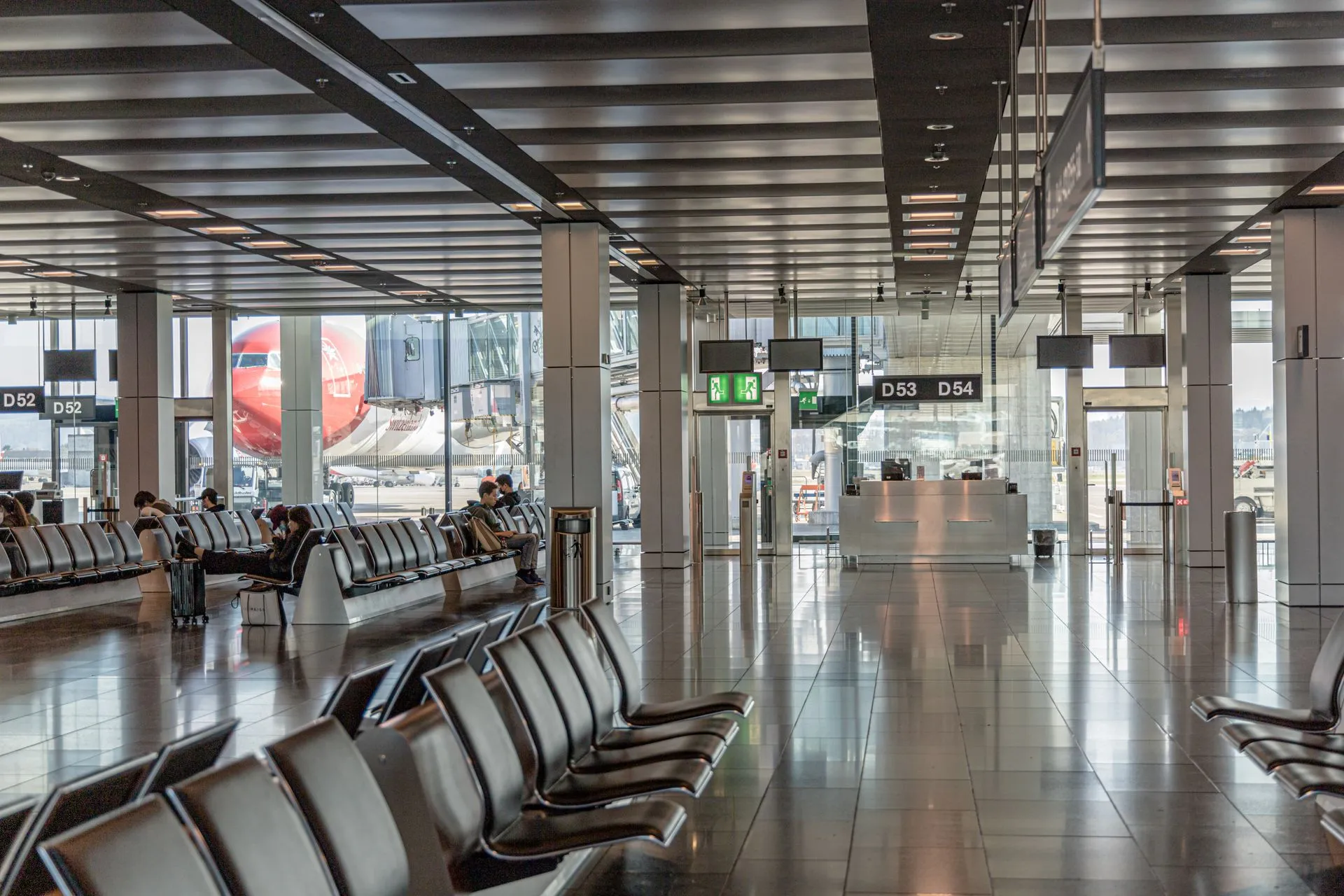 Spacious airport terminal with empty seating and a view of an airplane through large glass windows, illustrating 114 lawmakers challenge Google's $10 million Spirit Airlines AI