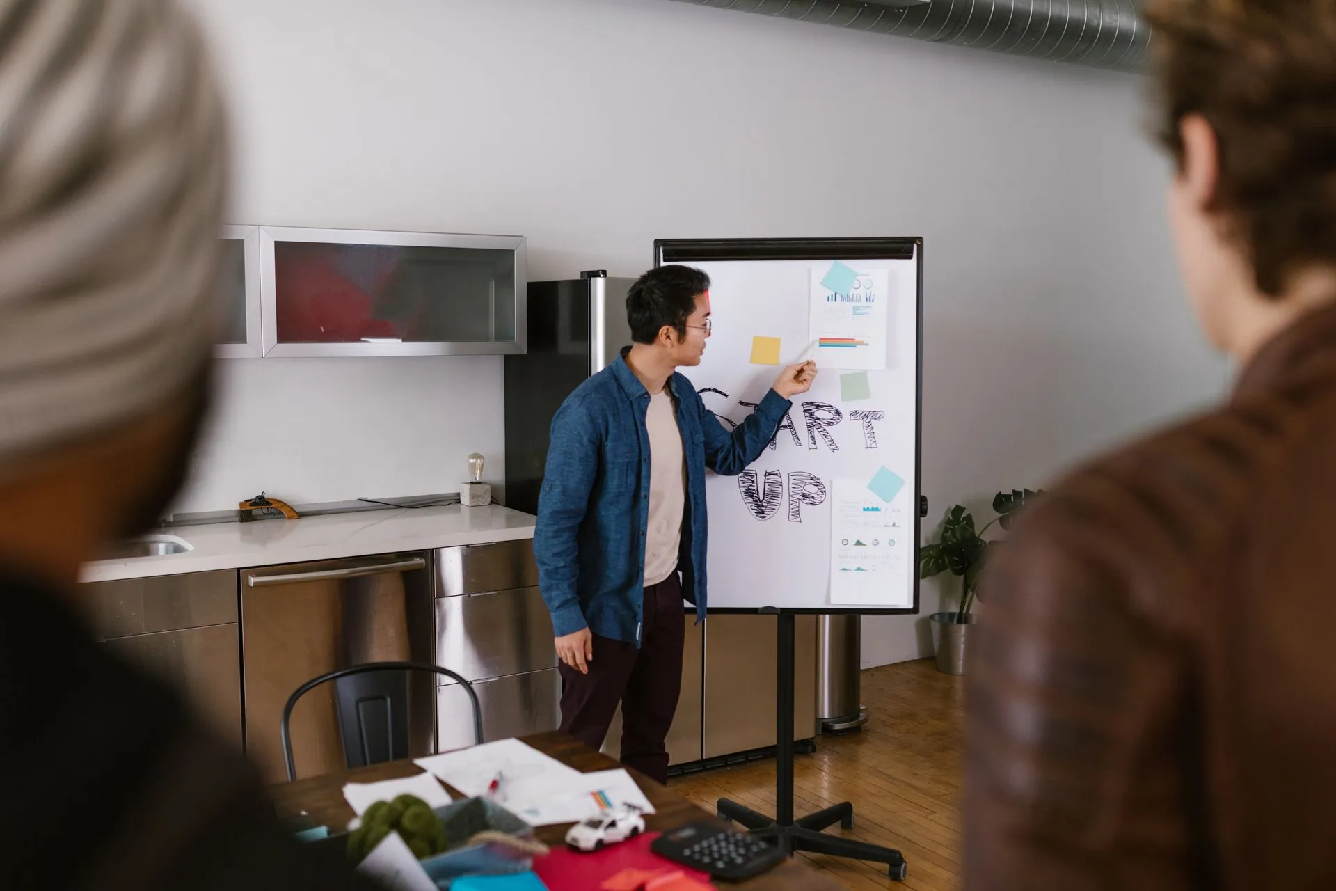 Team members discussing project ideas in a modern office setting, illustrating Early Groq backer's $52 million fund expects about half of its 35 startups to fail