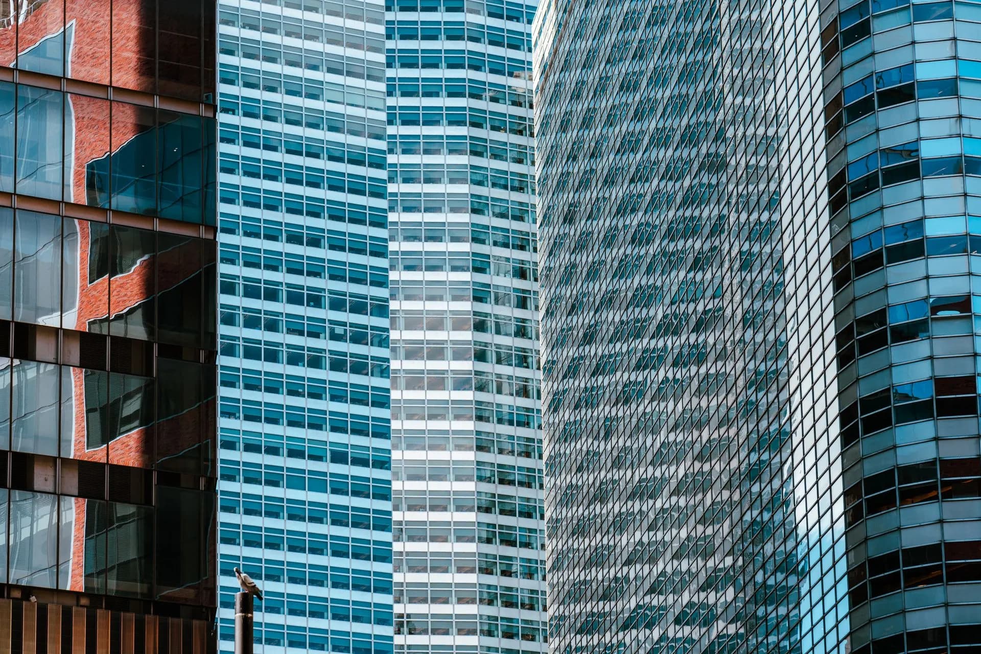 Close-up view of contemporary skyscrapers with reflections on glass facades in urban financial district, illustrating HPE lands first AMD Helios rack order in $1.2 billion deal with