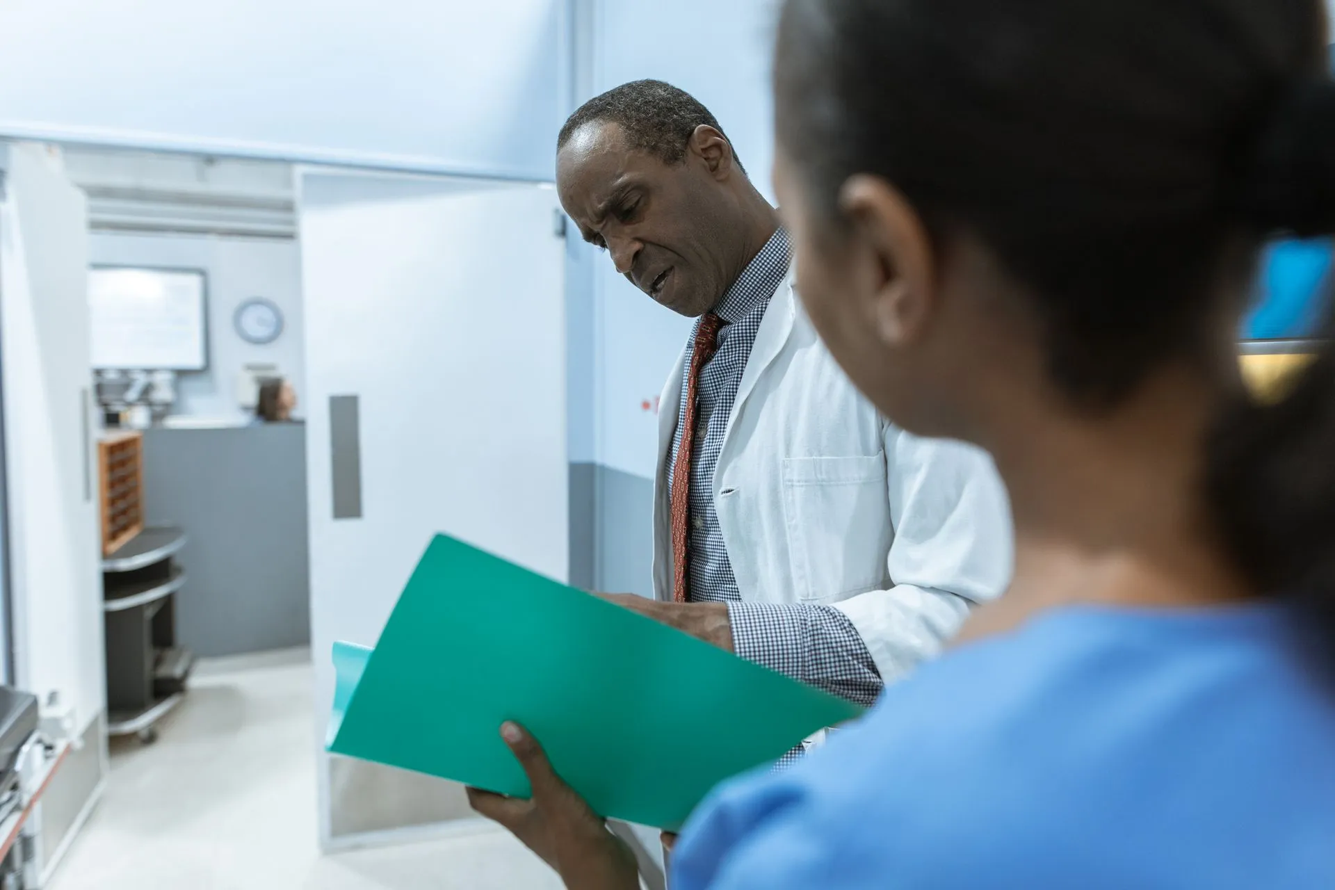 Doctors examining a folder in a hospital setting, highlighting teamwork and healthcare professionalism, illustrating IQVIA fined €7 million in Italy as attacks hit UIC, Clover Health