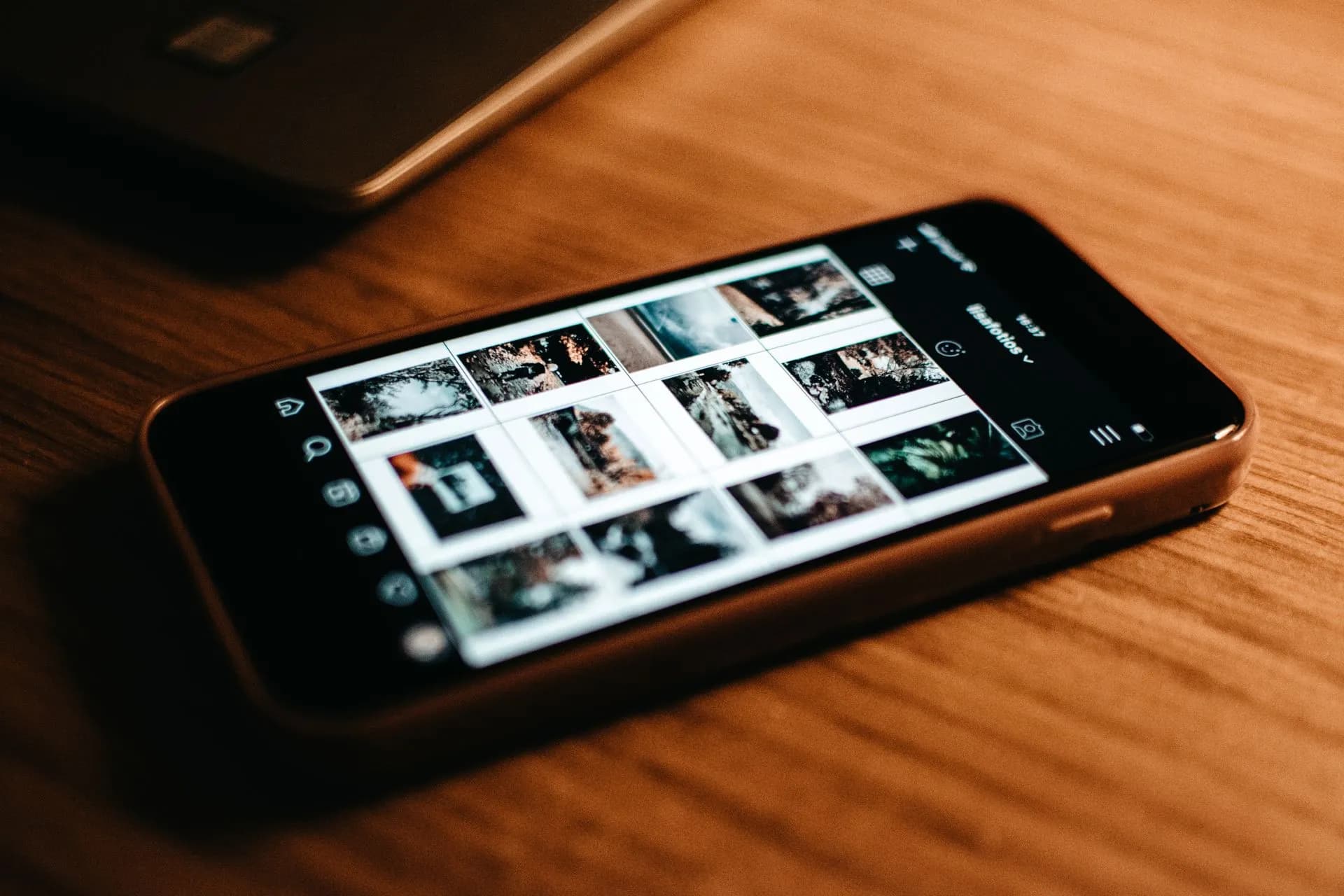 Close-up of smartphone showing photo gallery on wooden desk, illustrating Marissa Mayer's Dazzle analyzes your whole camera roll as AI agents race for personal data