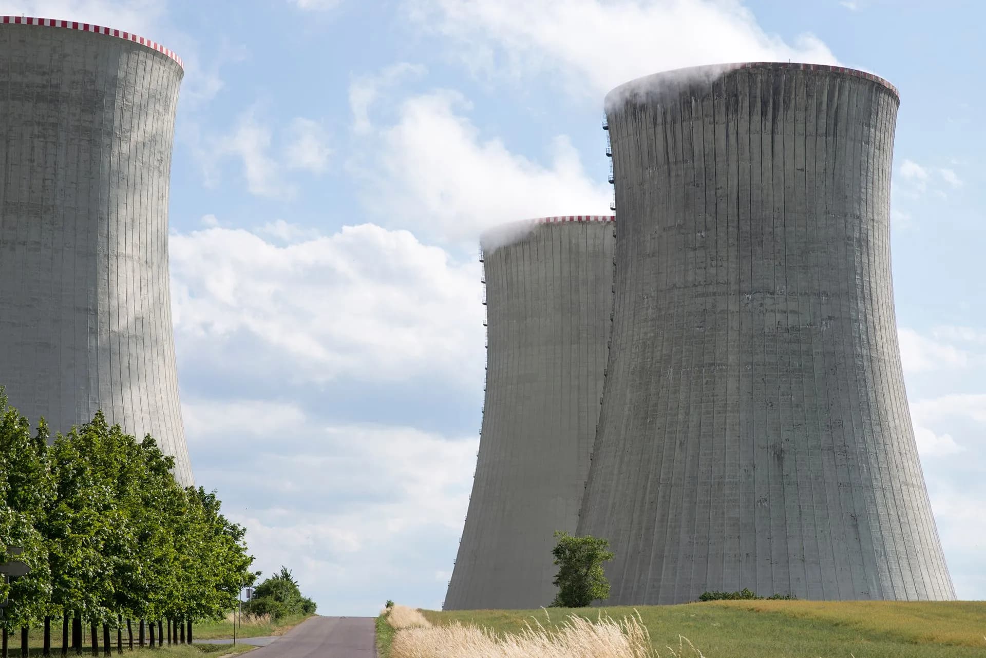 Cooling towers of Dukovany nuclear power plant with steam on a clear day, illustrating Meta claimed $3.9 billion in research tax credits for 2025 by treating AI data centers as
