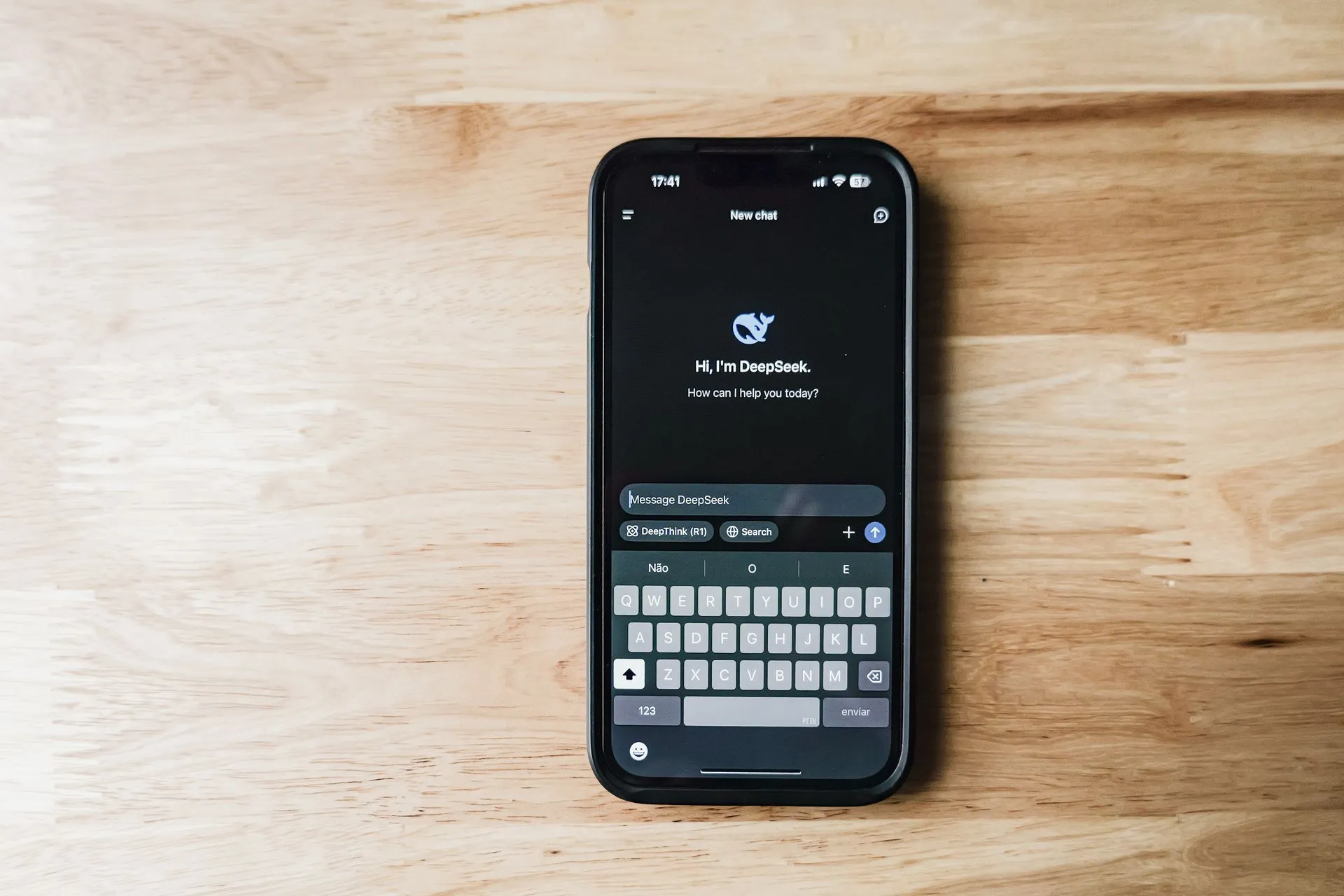 A smartphone on a wooden table showing an AI chatbot interface called DeepSeek, illustrating Meta Muse security concerns grow after a VM flaw and a tester's Messages sync report