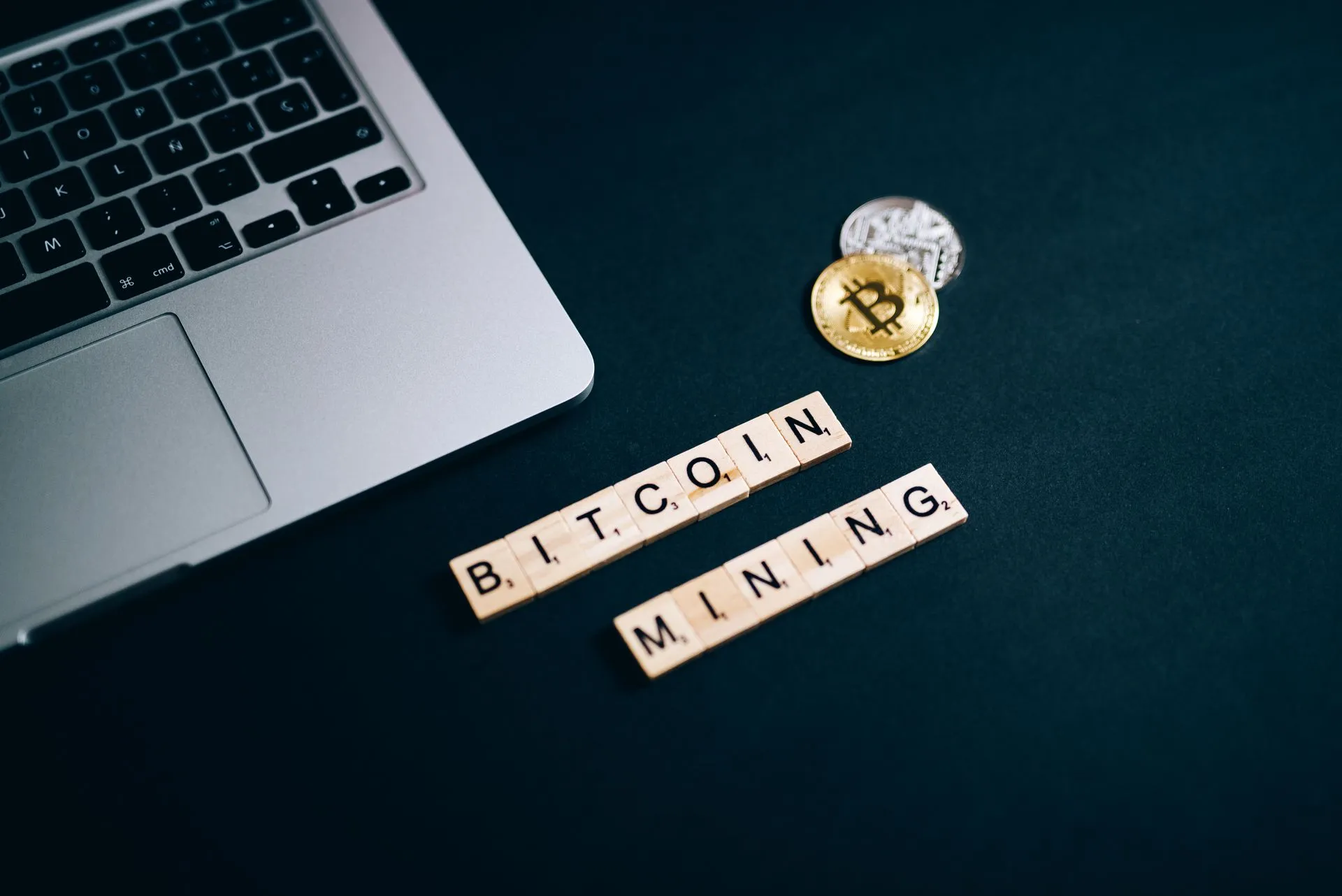 Top view of Bitcoin mining concept represented with laptop keyboard and Scrabble tiles, illustrating MetaMask discloses ongoing infrastructure security incident, exits Ethereum