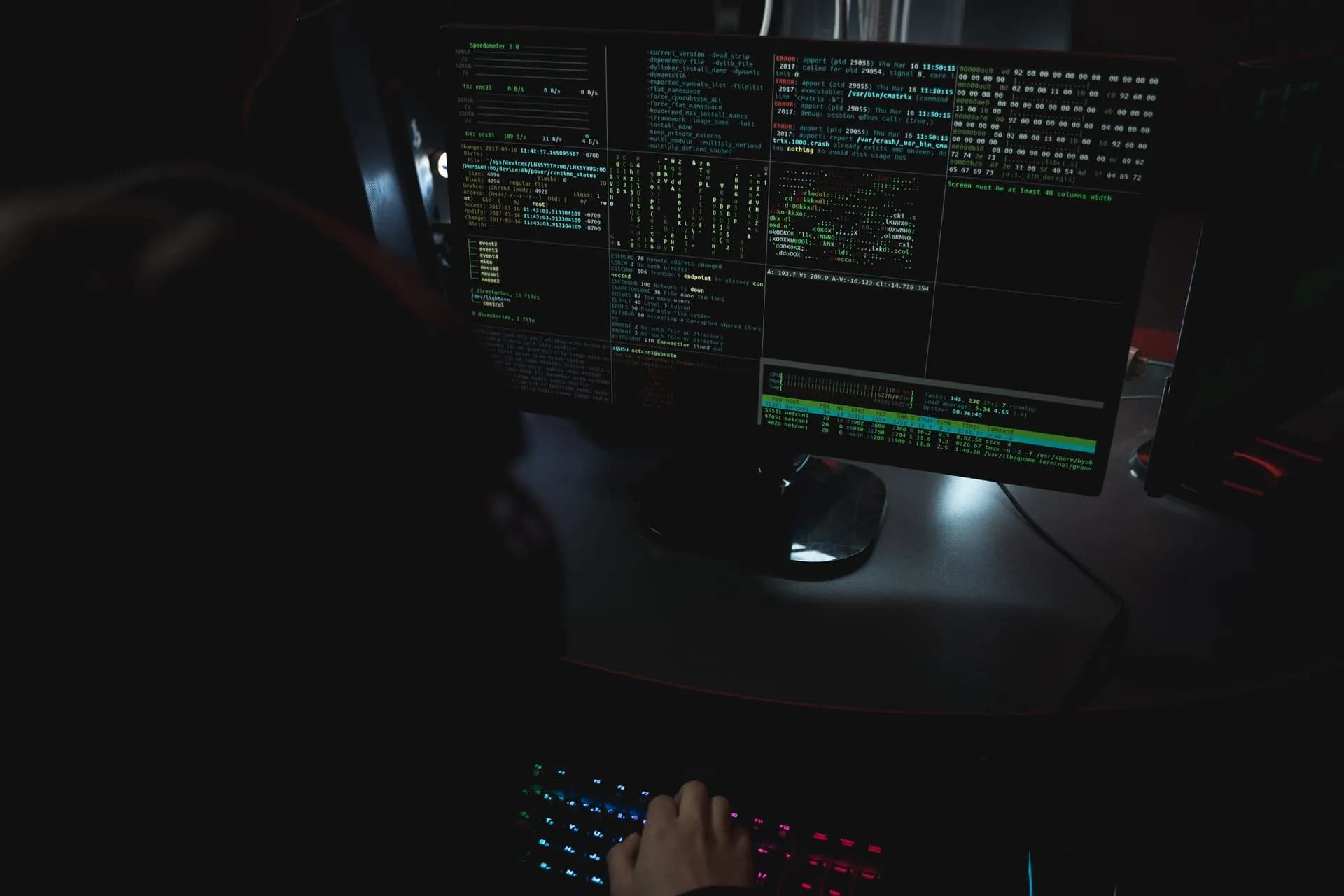 Dark room setup with code displayed on PC monitors highlighting cybersecurity themes, illustrating Microsoft Digital Defense Report says AI favors attackers