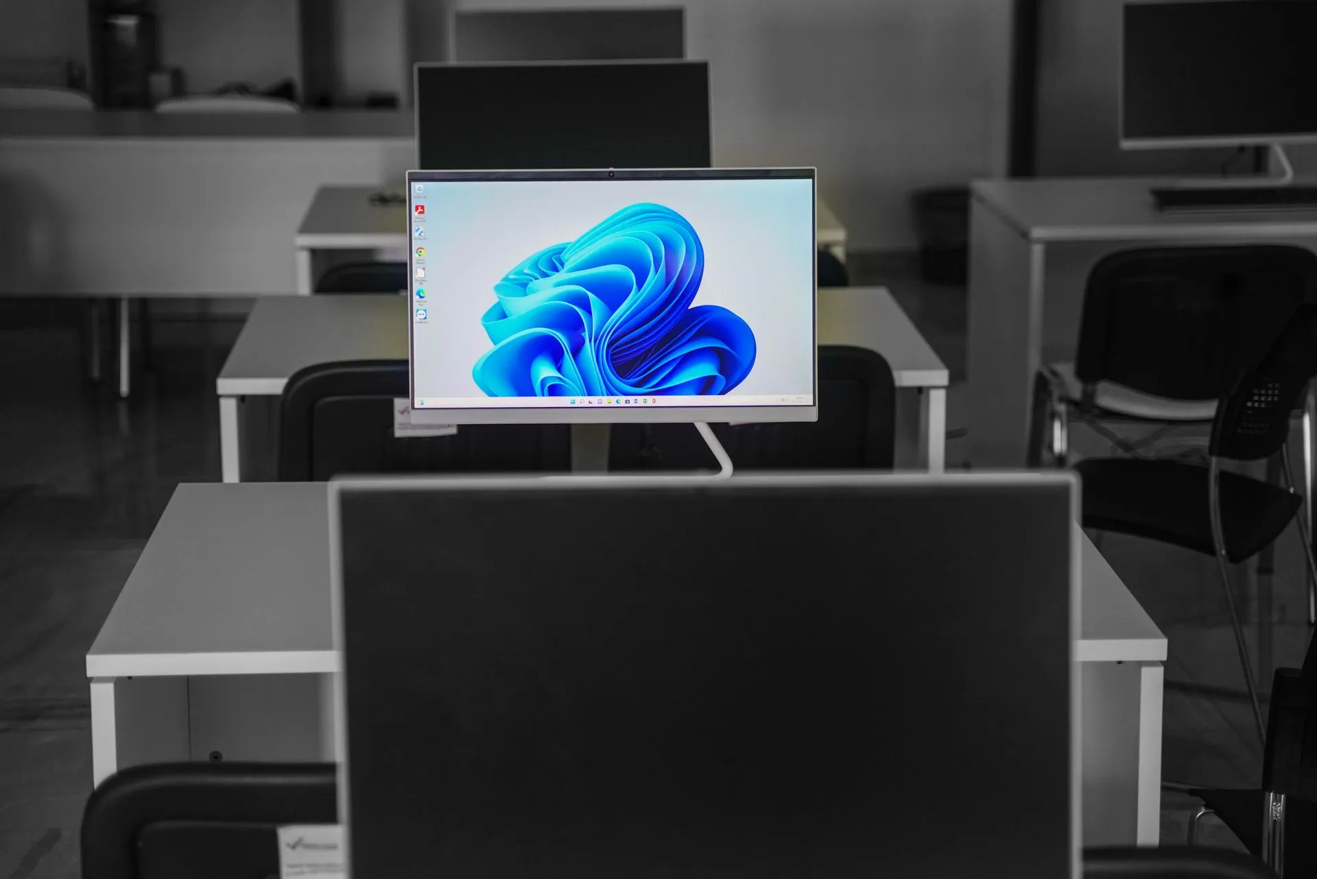 A contemporary office setup featuring computers on desks with modern flat screens, illustrating Microsoft Patch Tuesday sets 974-flaw record as researchers cite AI-assisted bug hunting